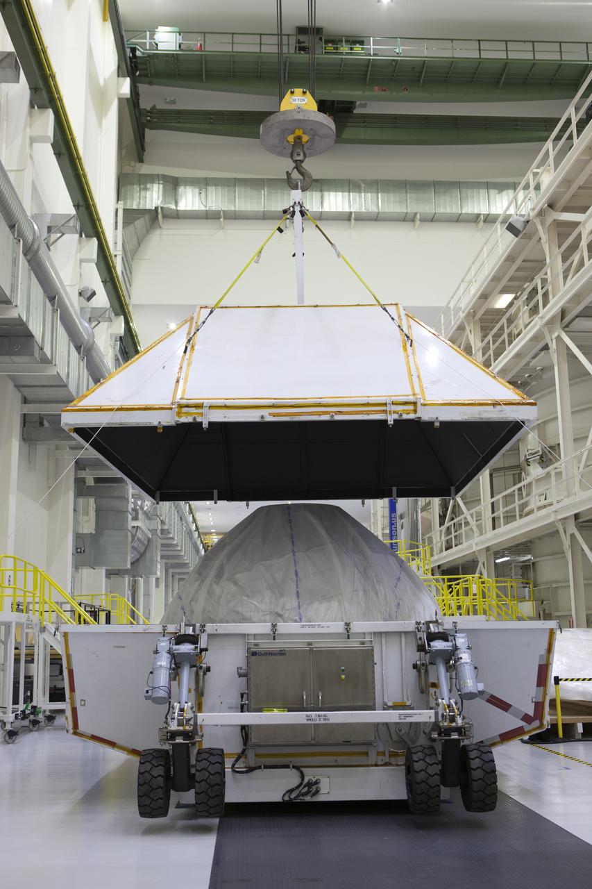 Inside the Neil Armstrong Operations and Checkout Building high bay at NASA's Kennedy Space Center in Florida, a crane lifts the cover up from the container holding the Orion crew module structural test article (STA). The STA arrived aboard NASA's Super Guppy aircraft at the Shuttle Landing Facility operated by Space Florida. The test article was moved inside the facility's high bay for further testing. The Orion spacecraft will launch atop NASA’s Space Launch System rocket on EM-1, its first deep space mission, in late 2018.