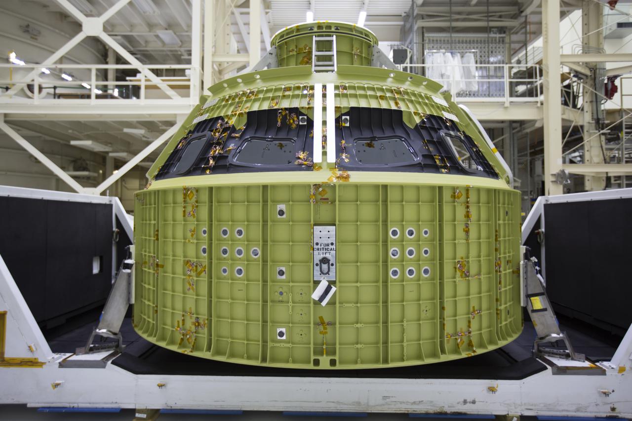 Inside the Neil Armstrong Operations and Checkout Building high bay at NASA's Kennedy Space Center in Florida, the protective covering was removed from the Orion crew module structural test article (STA). It remains secured on the bottom of its transport container. The STA arrived aboard NASA's Super Guppy aircraft at the Shuttle Landing Facility operated by Space Florida. The test article was moved inside the facility's high bay for further testing. The Orion spacecraft will launch atop NASA’s Space Launch System rocket on EM-1, its first deep space mission, in late 2018.