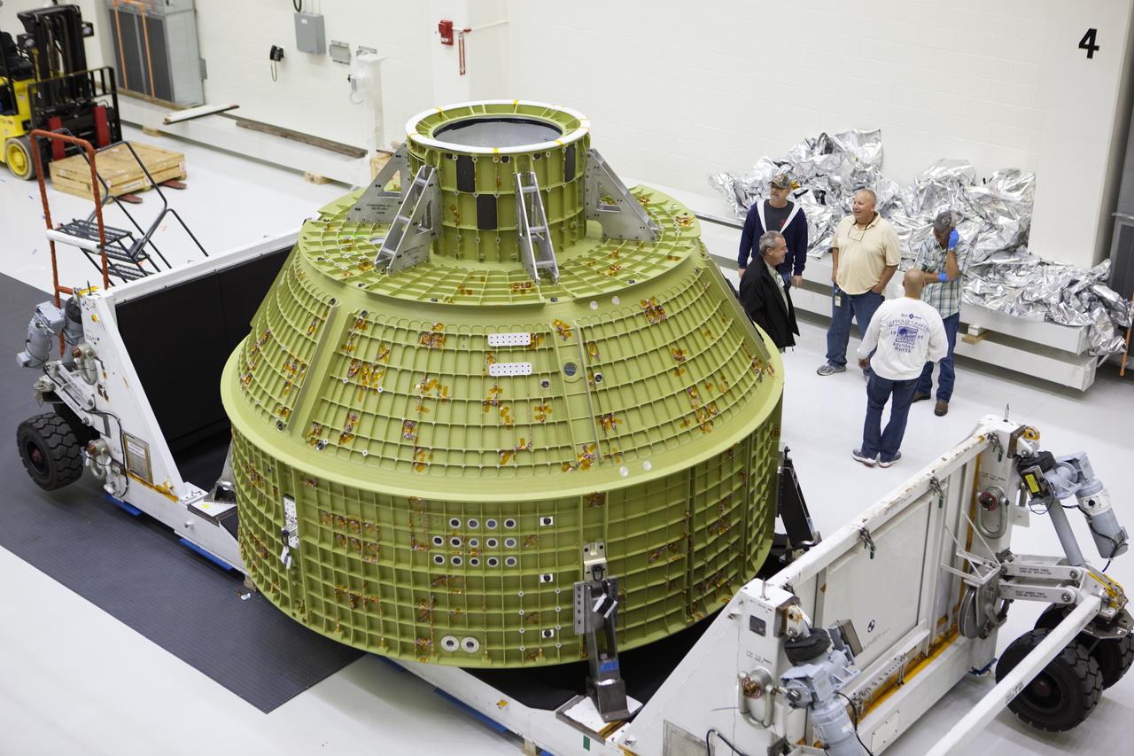 Inside the Neil Armstrong Operations and Checkout Building high bay at NASA's Kennedy Space Center in Florida, the protective covering was removed from the Orion crew module structural test article (STA). It remains secured on the bottom of its transport container. The STA arrived aboard NASA's Super Guppy aircraft at the Shuttle Landing Facility operated by Space Florida. The test article was moved inside the facility's high bay for further testing. The Orion spacecraft will launch atop NASA’s Space Launch System rocket on EM-1, its first deep space mission, in late 2018.