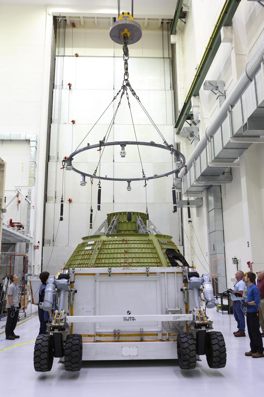 Inside the Neil Armstrong Operations and Checkout Building at NASA’s Kennedy Space Center in Florida, Lockheed Martin technicians prepare to attach lines from a crane to the Orion crew module structural test article (STA). The STA arrived aboard NASA's Super Guppy aircraft at the Shuttle Landing Facility operated by Space Florida. The test article will be lifted out of its container and moved to a test tool called the birdcage for further testing. The Orion spacecraft will launch atop NASA’s Space Launch System rocket on EM-1, its first deep space mission, in late 2018.