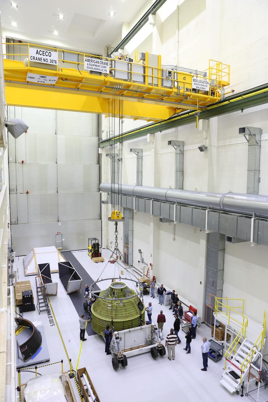 Inside the Neil Armstrong Operations and Checkout Building at NASA’s Kennedy Space Center in Florida, Lockheed Martin technicians attach lines from a crane to the Orion crew module structural test article (STA). The STA arrived aboard NASA's Super Guppy aircraft at the Shuttle Landing Facility operated by Space Florida. The test article will be lifted out of its container and moved to a test tool called the birdcage for further testing. The Orion spacecraft will launch atop NASA’s Space Launch System rocket on EM-1, its first deep space mission, in late 2018.