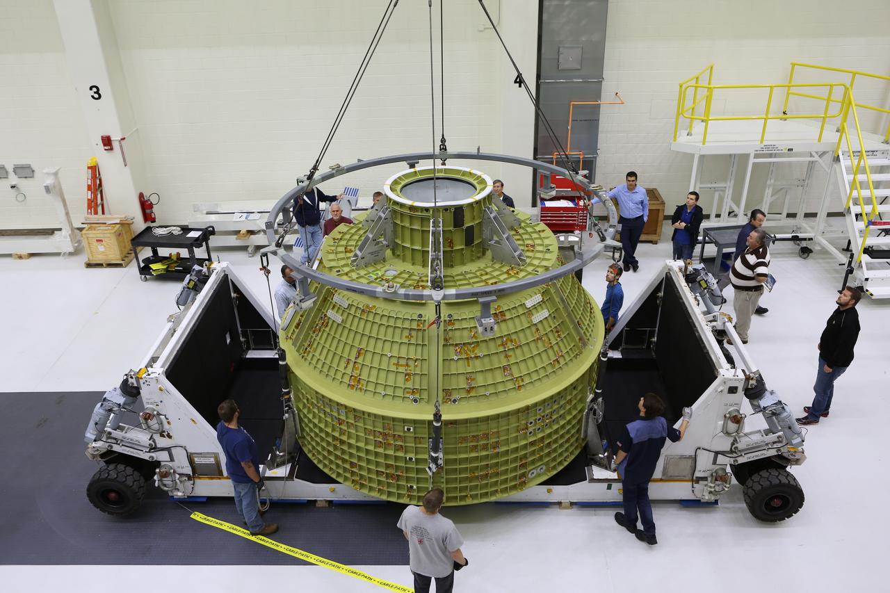 Inside the Neil Armstrong Operations and Checkout Building at NASA’s Kennedy Space Center in Florida, Lockheed Martin technicians monitor the progress as a crane begins to lift the Orion crew module structural test article (STA) up from the base of its transport container. The STA arrived aboard NASA's Super Guppy aircraft at the Shuttle Landing Facility operated by Space Florida. The test article will be moved to a test tool called the birdcage for further testing. The Orion spacecraft will launch atop NASA’s Space Launch System rocket on EM-1, its first deep space mission, in late 2018.