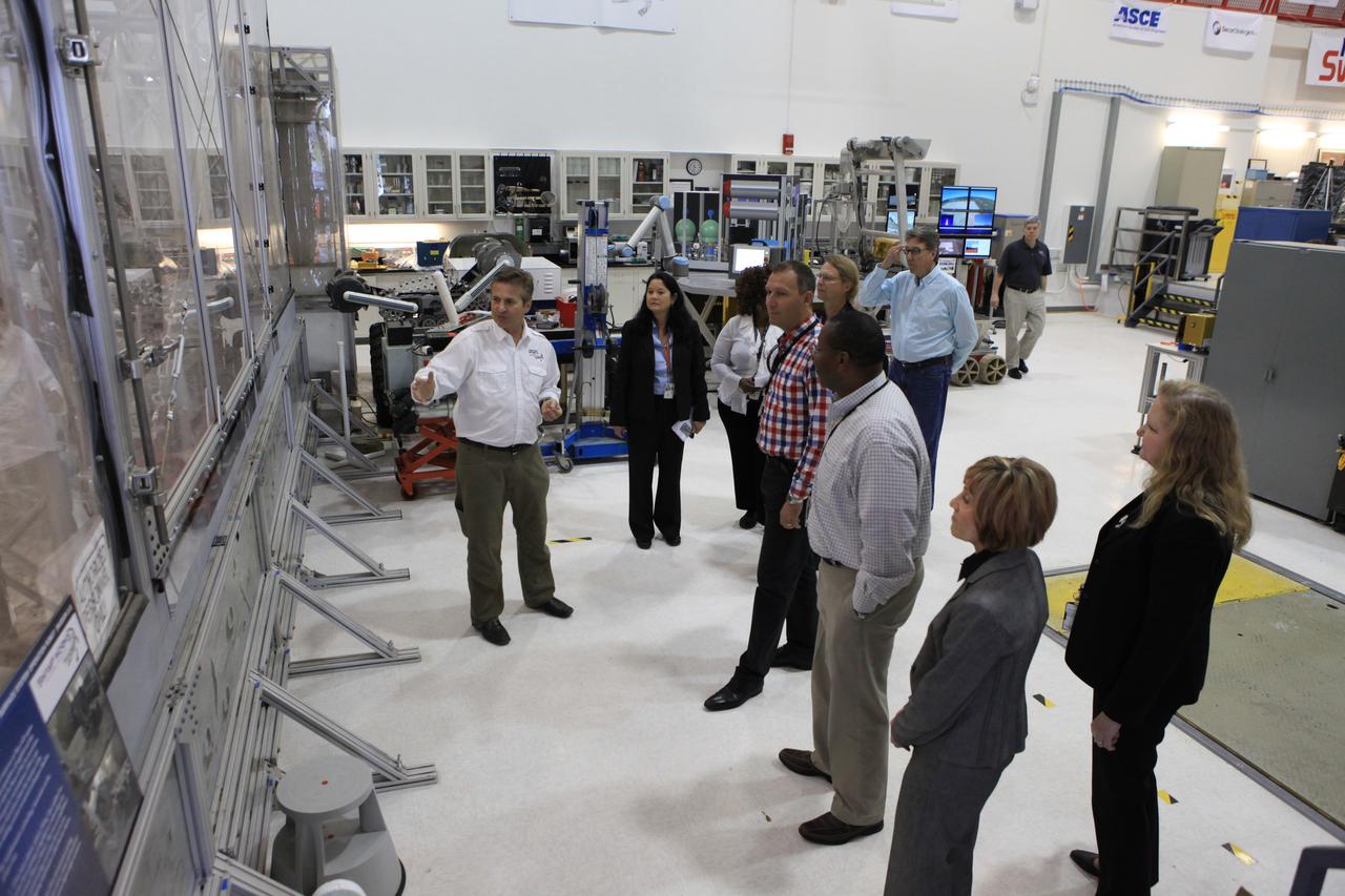 Thomas Zurbuchen, in plaid shirt, NASA's associate administrator for the Science Mission Directorate, listens to a presentation at the Swamp Works facility at NASA's Kennedy Space Center in Florida.