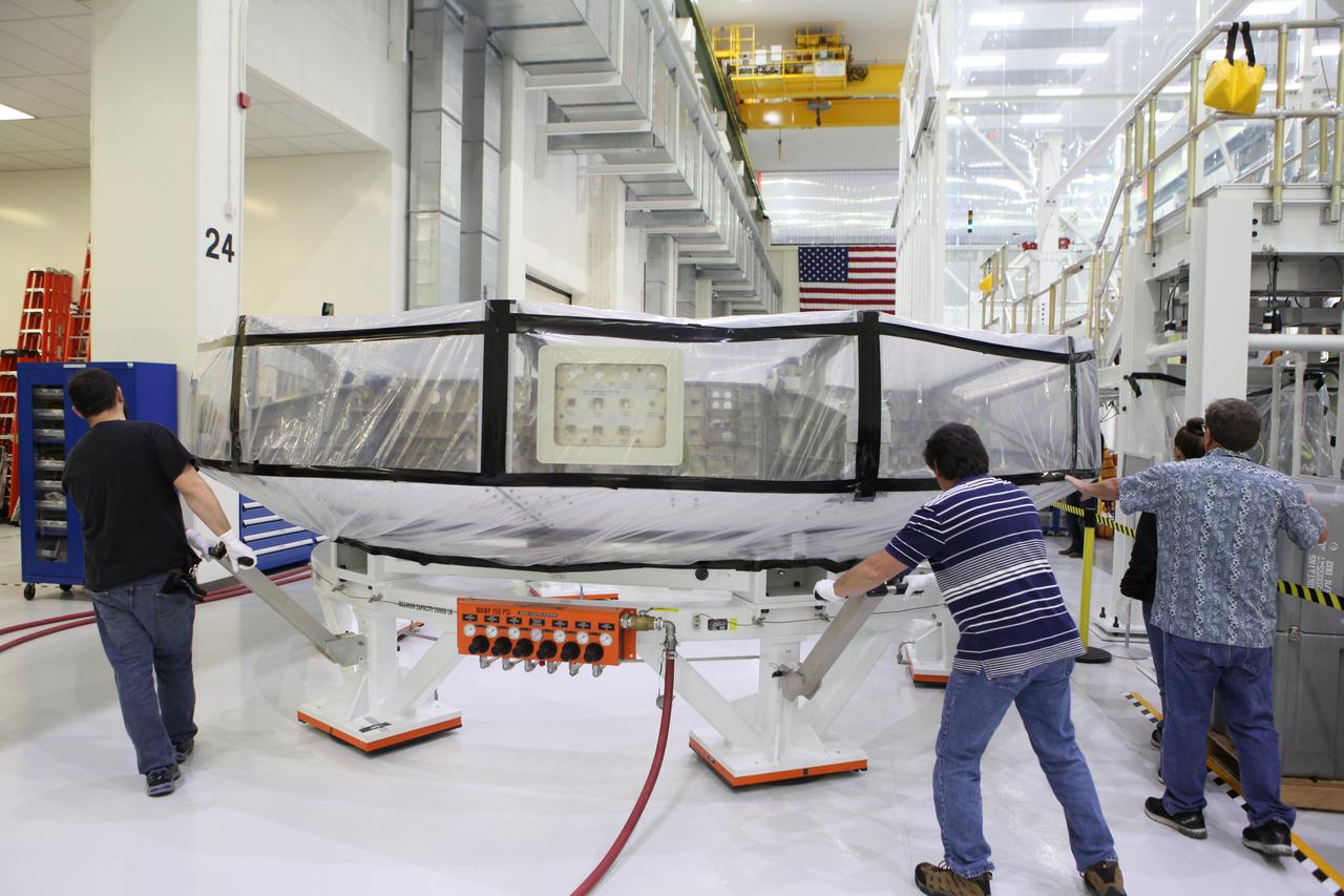 Inside the Neil Armstrong Operations and Checkout Building high bay at NASA’s Kennedy Space Center in Florida, Lockheed Martin technicians move the Orion crew module adapter (CMA) for Exploration Mission 1 (EM-1) toward a clean room. The CMA will undergo propellant and environmental control and life support system tube installation and welding. The adapter will connect the Orion crew module to the European Space Agency-provided service module. The Orion spacecraft will launch atop NASA’s Space Launch System rocket on EM-1, its first deep space mission, in late 2018. 