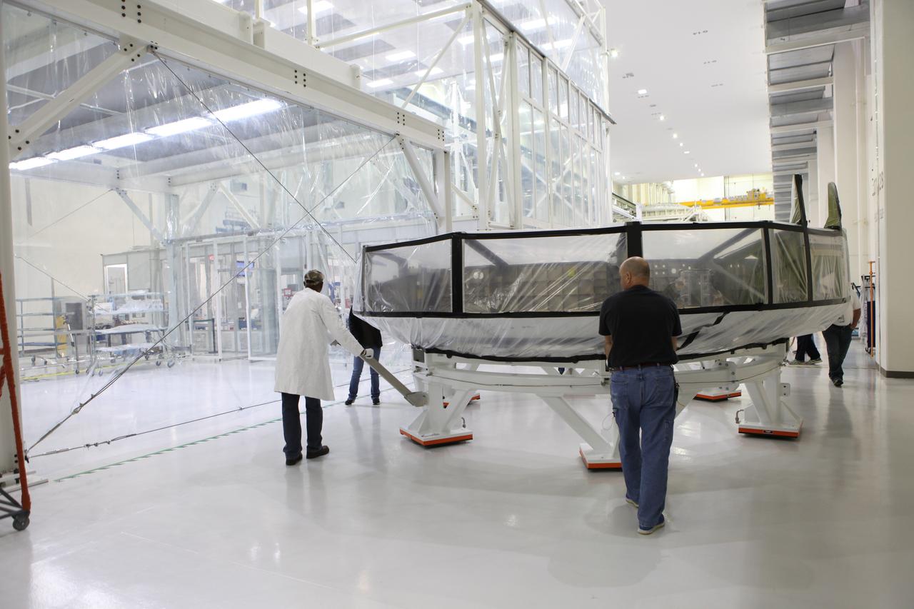 Inside the Neil Armstrong Operations and Checkout Building high bay at NASA’s Kennedy Space Center in Florida, Lockheed Martin technicians move the Orion crew module adapter (CMA) for Exploration Mission 1 (EM-1) toward a clean room. The CMA will undergo propellant and environmental control and life support system tube installation and welding. The adapter will connect the Orion crew module to the European Space Agency-provided service module. The Orion spacecraft will launch atop NASA’s Space Launch System rocket on EM-1, its first deep space mission, in late 2018. 