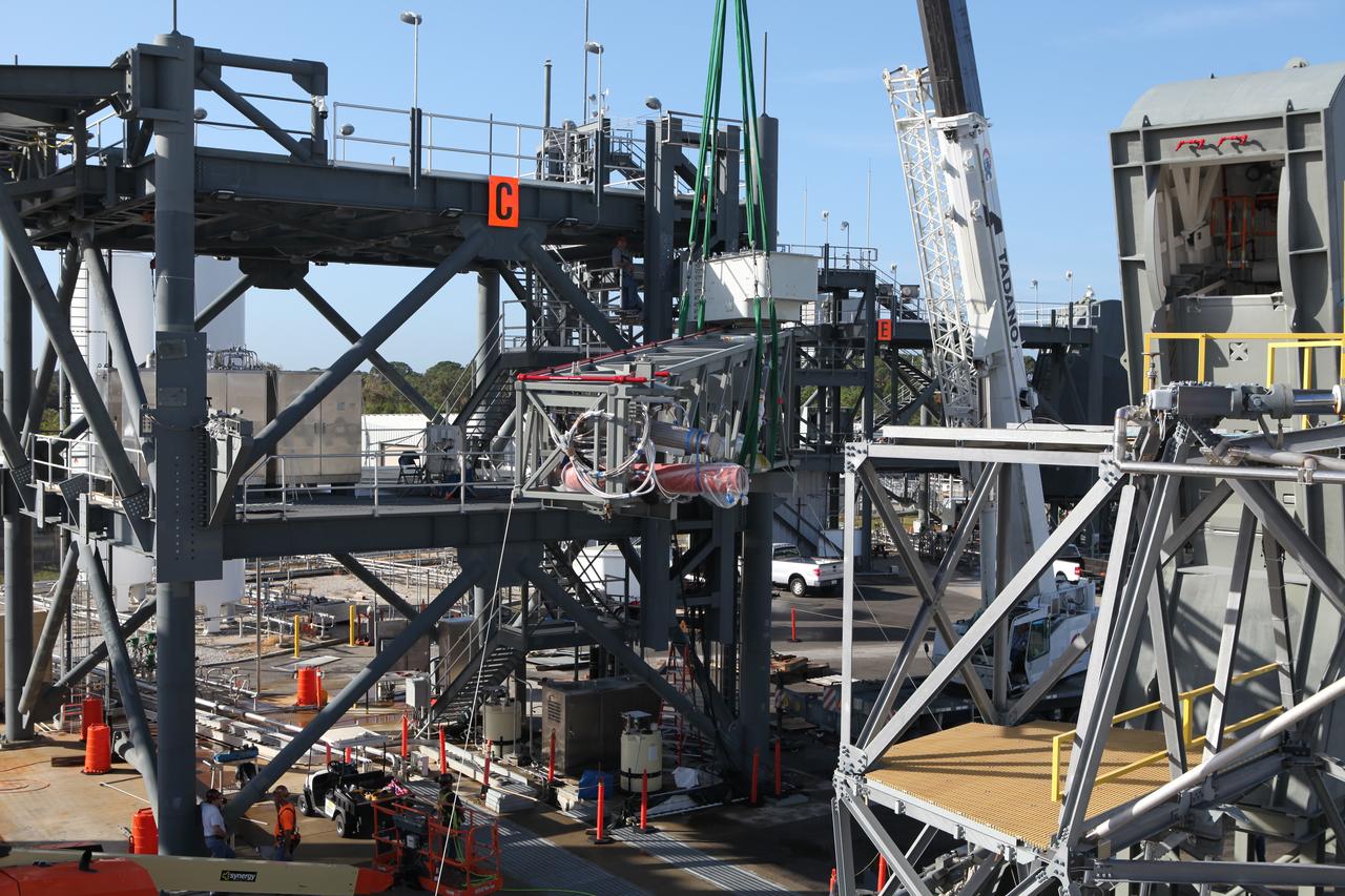 A crane lifts the Core State Inter-tank Umbilical (CSITU) for NASA's Space Launch System (SLS) at the Launch Equipment Test Facility at the agency's Kennedy Space Center in Florida. The CSITU will be attached to the "C" tower of the Vehicle Motion Simulator 2 test fixture. The umbilical will undergo a series of tests to confirm it is functioning properly and ready to support the SLS rocket for launch. The CSITU is a swing arm umbilical that will connect to the SLS core stage inter-tank. The umbilical's main function is to vent gaseous hydrogen from the core stage. The arm also provides conditioned air, pressurized gases, and power and data connection to the core stage. The center’s Engineering Directorate and the Ground Systems Development and Operations Program are overseeing processing and testing of the umbilicals.