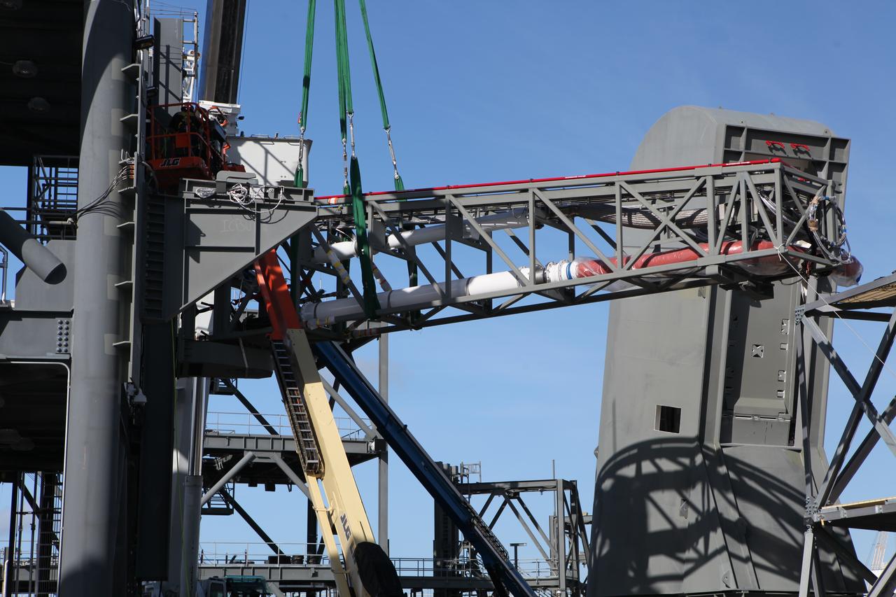 A crane moves the Core State Inter-tank Umbilical (CSITU) for NASA's Space Launch System (SLS) closer for attachment to the "C" tower of the Vehicle Motion Simulator 2 test fixture at the Launch Equipment Test Facility at the agency's Kennedy Space Center in Florida. The umbilical will undergo a series of tests to confirm it is functioning properly and ready to support the SLS rocket for launch. The CSITU is a swing arm umbilical that will connect to the SLS core stage inter-tank. The umbilical's main function is to vent gaseous hydrogen from the core stage. The arm also provides conditioned air, pressurized gases, and power and data connection to the core stage. The center’s Engineering Directorate and the Ground Systems Development and Operations Program are overseeing processing and testing of the umbilicals.