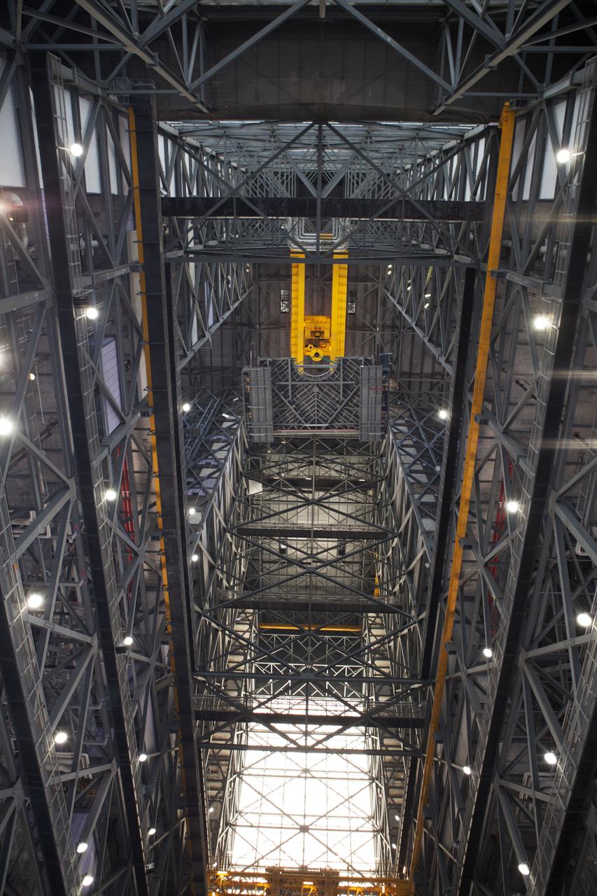 A heavy-lift crane lifts the first half of the B-level work platforms, B south, for NASA’s Space Launch System (SLS) rocket, high up from the transfer aisle floor of the Vehicle Assembly Building (VAB) at NASA’s Kennedy Space Center in Florida. The B platform will be installed on the south side of High Bay 3. The B platforms are the ninth of 10 levels of work platforms that will surround and provide access to the SLS rocket and Orion spacecraft for Exploration Mission 1. The Ground Systems Development and Operations Program is overseeing upgrades and modifications to VAB High Bay 3, including installation of the new work platforms, to prepare for NASA’s Journey to Mars. 