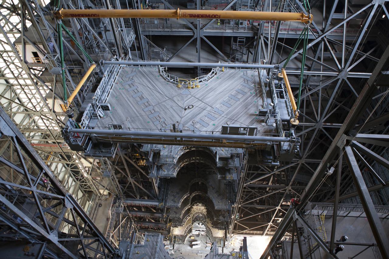 A heavy-lift crane lowers the first half of the B-level work platforms, B south, for NASA’s Space Launch System (SLS) rocket, for installation on the south side of High Bay 3 in the Vehicle Assembly Building (VAB) at NASA’s Kennedy Space Center in Florida. Large Tandemloc bars have been attached to the platform to keep it level during lifting and installation. In view below are eight levels of previously installed platforms. The B platforms are the ninth of 10 levels of work platforms that will surround and provide access to the SLS rocket and Orion spacecraft for Exploration Mission 1. The Ground Systems Development and Operations Program is overseeing upgrades and modifications to VAB High Bay 3, including installation of the new work platforms, to prepare for NASA’s Journey to Mars.