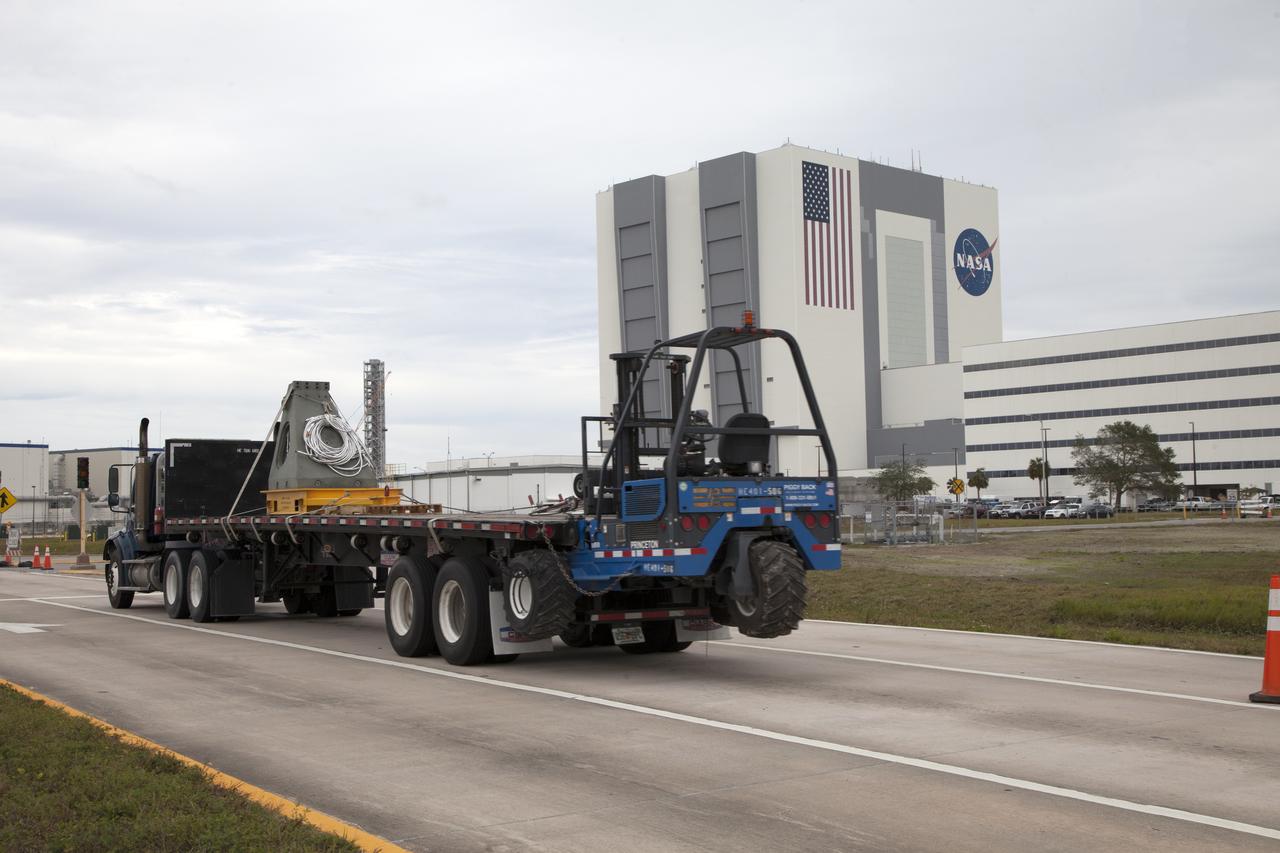 A flatbed truck carries a vertical support post (VSP) for NASA's Space Launch System (SLS) rocket to the Mobile Launcher Yard at NASA's Kennedy Space Center in Florida. The two aft skirt electrical umbilicals (ASEUs) and the first of the vehicle support posts underwent a series of tests to confirm they are functioning properly and ready to support the SLS for launch. The ASEUs will connect to the SLS rocket at the bottom outer edge of each booster and provide electrical power and data connections to the rocket until it lifts off from the launch pad. The eight VSPs will support the load of the solid rocket boosters, with four posts for each of the boosters. The center’s Engineering Directorate and the Ground Systems Development and Operations Program are overseeing processing and testing of the umbilicals. 