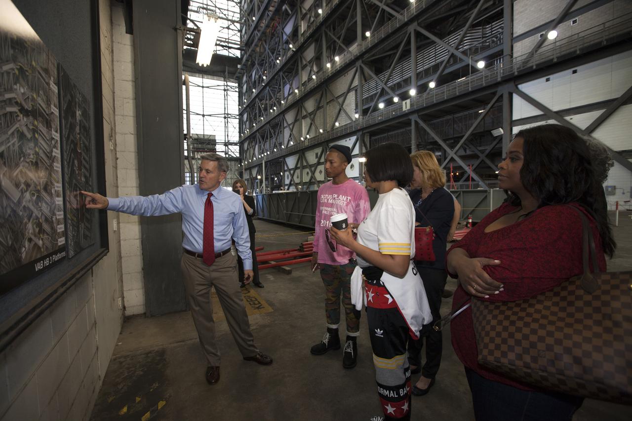 Kennedy Space Center Director Bob Cabana points to a display during a tour for cast and crew members of the upcoming motion picture "Hidden Figures." The group is walking thought the transfer aisle of the Vehicle Assembly Building. The movie is based on the book of the same title, by Margot Lee Shetterly. It chronicles the lives of Katherine Johnson, Dorothy Vaughan and Mary Jackson, three African-American women who worked for NASA as human "computers.” Their mathematical calculations were crucial to the success of Project Mercury missions including John Glenn’s orbital flight aboard Friendship 7 in 1962. The film is due in theaters in January 2017.