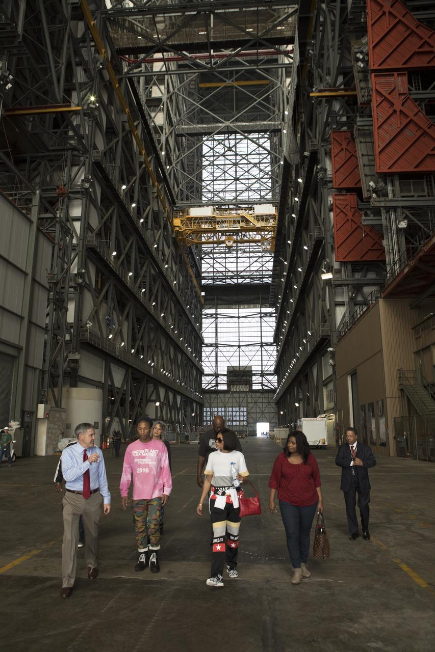Kennedy Space Center Director Bob Cabana provides a tour for cast and crew members of the upcoming motion picture "Hidden Figures." From the left are Cabana, Pharrell Williams, musician and producer of “Hidden Figures," Taraji P. Henson, who portrays Katherine Johnson in the film, and Octavia Spencer, who portrays Dorothy Vaughan. The group is walking thought the transfer aisle of the Vehicle Assembly Building. The movie is based on the book of the same title, by Margot Lee Shetterly. It chronicles the lives of Katherine Johnson, Dorothy Vaughan and Mary Jackson, three African-American women who worked for NASA as human "computers.” Their mathematical calculations were crucial to the success of Project Mercury missions including John Glenn’s orbital flight aboard Friendship 7 in 1962. The film is due in theaters in January 2017.
