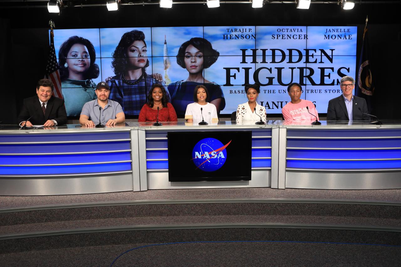 In the Press Site auditorium at the Kennedy Space Center in Florida, members of the media participate in a news conference with key individuals from the upcoming motion picture "Hidden Figures." From the left are: former CNN space correspondent John Zarrella, serving as moderator; Ted Melfi, writer and director of “Hidden Figures”; Octavia Spencer, who portrays Dorothy Vaughan; Taraji P. Henson, who portrays Katherine Johnson in the film; Janelle Monáe, who portrays Mary Jackson; Pharrell Williams, musician and producer of “Hidden Figures"; and Bill Barry, NASA's chief historian. The movie is based on the book of the same title, by Margot Lee Shetterly. It chronicles the lives of Katherine Johnson, Dorothy Vaughan and Mary Jackson, three African-American women who worked for NASA as human "computers.” Their mathematical calculations were crucial to the success of Project Mercury missions including John Glenn’s orbital flight aboard Friendship 7 in 1962. The film is due in theaters in January 2017.