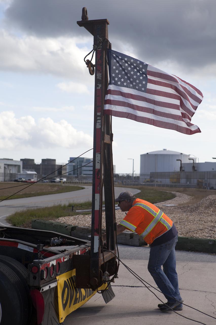 The American flag is in view on the back of a heavy load transport truck from Tillett Heavy Hauling in Titusville, Florida, as it arrives at NASA’s Kennedy Space Center in Florida. The truck is carrying the second half of the A-level work platforms, A north, for the agency’s Space Launch System (SLS) rocket. This is the final platform delivered to Kennedy. The A-level platforms are the topmost platforms for High Bay 3 in the Vehicle Assembly Building (VAB). The platform will be delivered to the VAB staging area in the west parking lot. The Ground Systems Development and Operations Program is overseeing upgrades and modifications to High Bay 3 to support processing of the SLS and Orion spacecraft. A total of 10 levels of new platforms, 20 platform halves altogether, will surround the SLS rocket and Orion spacecraft and provide access for testing and processing. 
