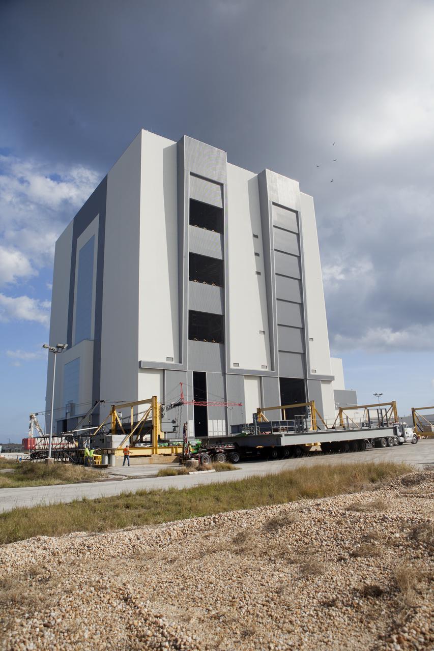 A heavy load transport truck from Tillett Heavy Hauling in Titusville, Florida, arrives at the Vehicle Assembly Building (VAB) at NASA’s Kennedy Space Center in Florida, carrying the second half of the A-level work platforms, A north, for the agency’s Space Launch System (SLS) rocket. This is the final platform delivered to Kennedy. The A-level platforms are the topmost platforms for High Bay 3 in the Vehicle Assembly Building (VAB). The platform will be delivered to the VAB staging area in the west parking lot. The Ground Systems Development and Operations Program is overseeing upgrades and modifications to High Bay 3 to support processing of the SLS and Orion spacecraft. A total of 10 levels of new platforms, 20 platform halves altogether, will surround the SLS rocket and Orion spacecraft and provide access for testing and processing.