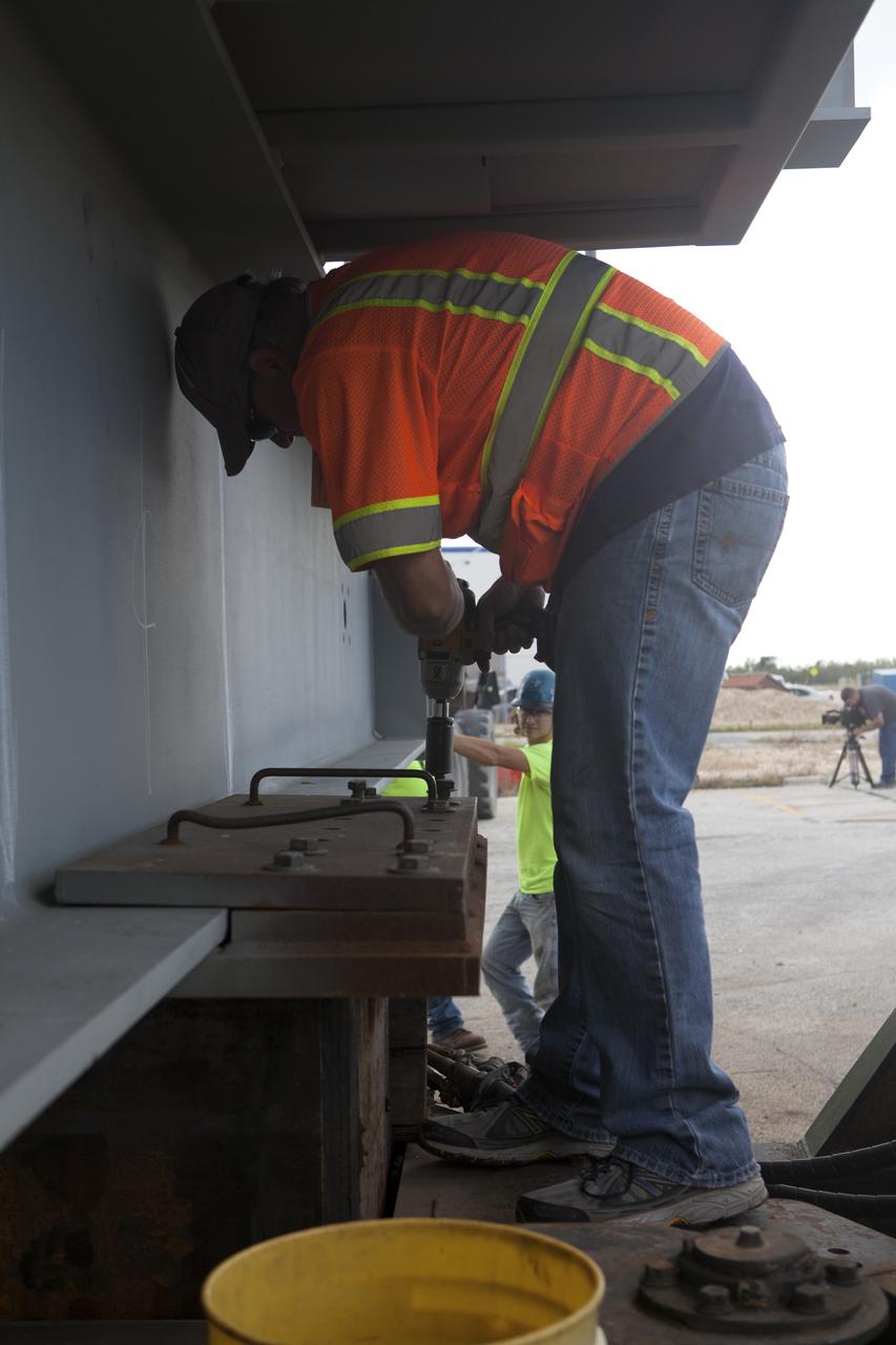 Workers prepare to unload the second half of the A-level work platforms, A north, for NASA's Space Launch System (SLS) rocket, from a heavy load transport truck near the Vehicle Assembly Building (VAB) at NASA's Kennedy Space Center in Florida. This is the final platform delivered to Kennedy. The platform will be offloaded in a staging area near the VAB. The A-level platforms are the topmost platforms for High Bay 3 in the VAB. The Ground Systems Development and Operations Program is overseeing upgrades and modifications to High Bay 3 to support processing of the SLS and Orion spacecraft. A total of 10 levels of new platforms, 20 platform halves altogether, will surround the SLS rocket and Orion spacecraft and provide access for testing and processing. 