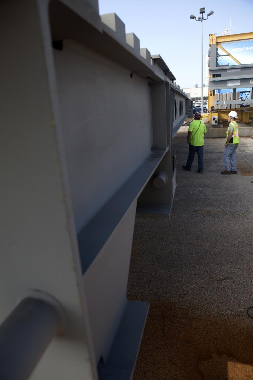 Workers prepare to unload the second half of the A-level work platforms, A north, for NASA's Space Launch System (SLS) rocket, from a heavy load transport truck in a staging area near the Vehicle Assembly Building (VAB) at NASA's Kennedy Space Center in Florida. This is the final platform delivered to Kennedy. The A-level platforms are the topmost platforms for High Bay 3 in the VAB. The Ground Systems Development and Operations Program is overseeing upgrades and modifications to High Bay 3 to support processing of the SLS and Orion spacecraft. A total of 10 levels of new platforms, 20 platform halves altogether, will surround the SLS rocket and Orion spacecraft and provide access for testing and processing.