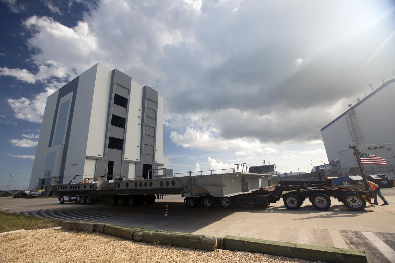 A heavy load transport truck from Tillett Heavy Hauling in Titusville, Florida, arrives at the Vehicle Assembly Building (VAB) at NASA’s Kennedy Space Center in Florida, carrying the second half of the A-level work platforms, A north, for the agency’s Space Launch System (SLS) rocket. This is the final platform delivered to Kennedy. The A-level platforms are the topmost platforms for High Bay 3 in the Vehicle Assembly Building (VAB). The platform will be delivered to the VAB staging area in the west parking lot. The Ground Systems Development and Operations Program is overseeing upgrades and modifications to High Bay 3 to support processing of the SLS and Orion spacecraft. A total of 10 levels of new platforms, 20 platform halves altogether, will surround the SLS rocket and Orion spacecraft and provide access for testing and processing.