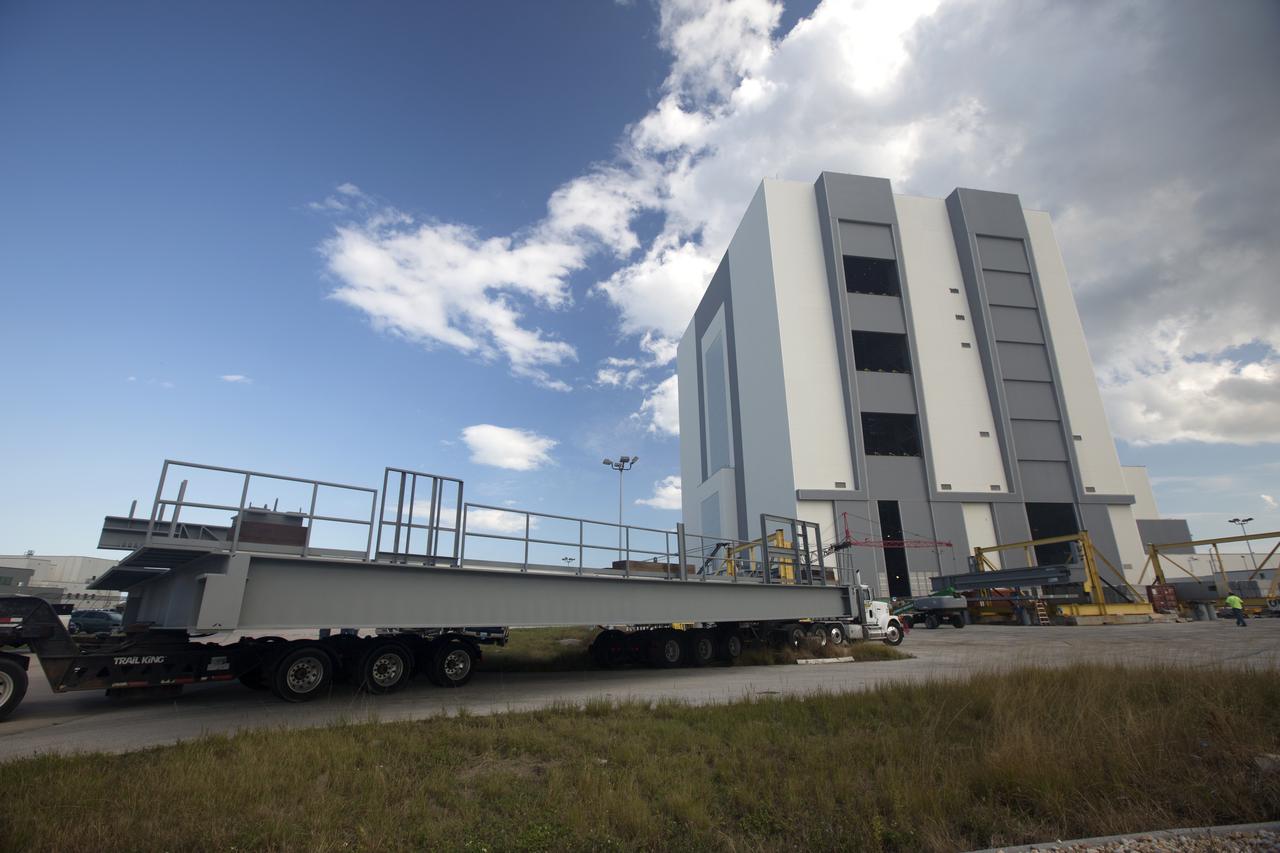A heavy load transport truck from Tillett Heavy Hauling in Titusville, Florida, arrives at the Vehicle Assembly Building (VAB) at NASA’s Kennedy Space Center in Florida, carrying the second half of the A-level work platforms, A north, for the agency’s Space Launch System (SLS) rocket. This is the final platform delivered to Kennedy. The A-level platforms are the topmost platforms for High Bay 3 in the Vehicle Assembly Building (VAB). The platform will be delivered to the VAB staging area in the west parking lot. The Ground Systems Development and Operations Program is overseeing upgrades and modifications to High Bay 3 to support processing of the SLS and Orion spacecraft. A total of 10 levels of new platforms, 20 platform halves altogether, will surround the SLS rocket and Orion spacecraft and provide access for testing and processing.