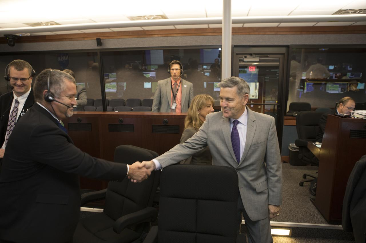 In the Mission Director's Center at Cape Canaveral Air Force Station, Kennedy Space Center Director Bob Cabana, right, congratulates, Omar Baez, a senior launch director in NASA's Launch Services Program, after the successful launch of eight Cyclone Global Navigation Satellite System, or CYGNSS, spacecraft. The satellites will make frequent and accurate measurements of ocean surface winds throughout the life cycle of tropical storms and hurricanes. The data that CYGNSS provides will enable scientists to probe key air-sea interaction processes that take place near the core of storms, which are rapidly changing and play a crucial role in the beginning and intensification of hurricanes.