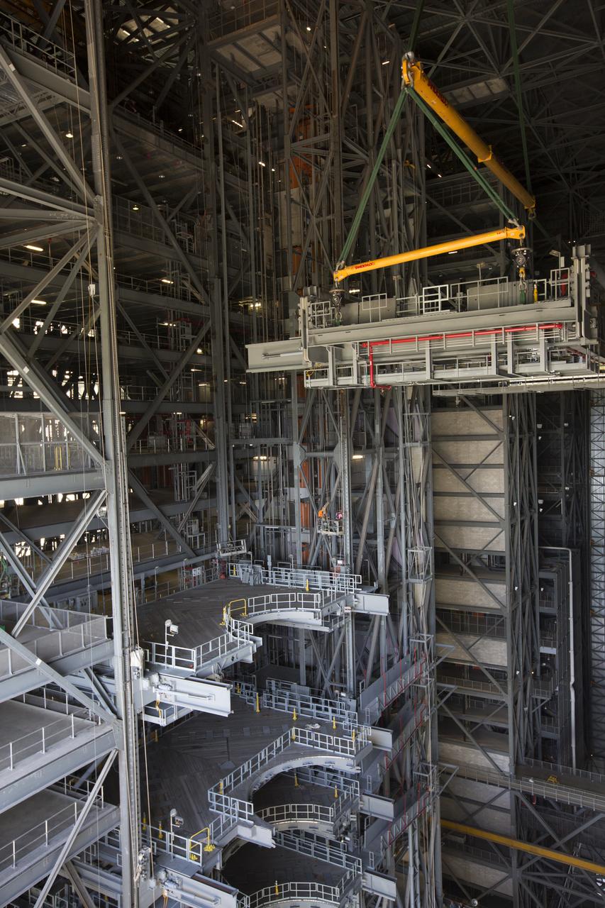 The second half of the B-level work platforms, B north, for NASA's Space Launch System (SLS) rocket, is lowered by crane for installation on the north side of High Bay 3 in the Vehicle Assembly Building (VAB) at NASA's Kennedy Space Center in Florida. Construction workers will secure the large bolts that hold the platform in place on the north wall. The B platforms are the ninth of 10 levels of work platforms that will surround and provide access to the SLS rocket and Orion spacecraft for Exploration Mission 1. The Ground Systems Development and Operations Program is overseeing upgrades and modifications to VAB High Bay 3, including installation of the new work platforms, to prepare for NASA’s Journey to Mars. 