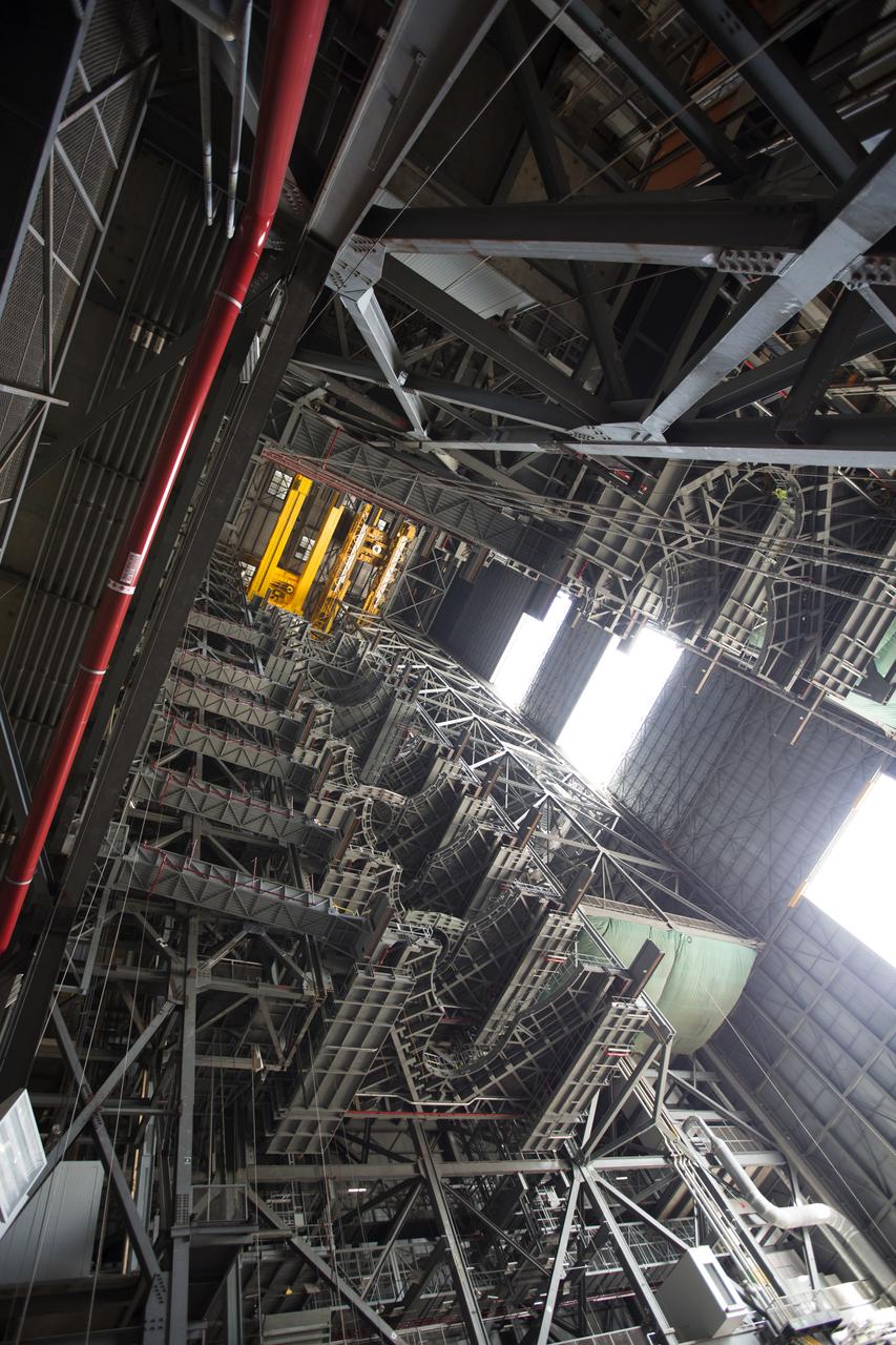 High up in the Vehicle Assembly Building (VAB) at NASA's Kennedy Space Center in Florida, a crane lowers the second half of the B-level work platforms, B north, for NASA's Space Launch System (SLS) rocket, for installation in High Bay 3. The B platform will be installed on the north side of high bay. In view below are eight levels of previously installed platforms. The B platforms are the ninth of 10 levels of work platforms that will surround and provide access to the SLS rocket and Orion spacecraft for Exploration Mission 1. The Ground Systems Development and Operations Program is overseeing upgrades and modifications to VAB High Bay 3, including installation of the new work platforms, to prepare for NASA’s Journey to Mars. 