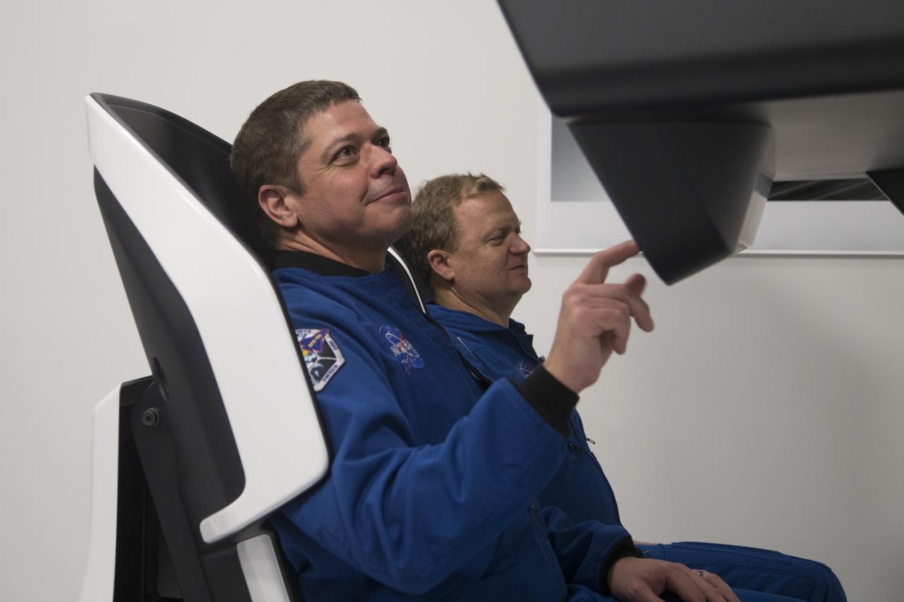 Astronauts Bob Behnken, left, and Eric Boe work in a mock-up of the SpaceX Crew Dragon flight deck at the company's Hawthorne, California, headquarters as development of the crew systems continues for eventual missions to the International Space Station.