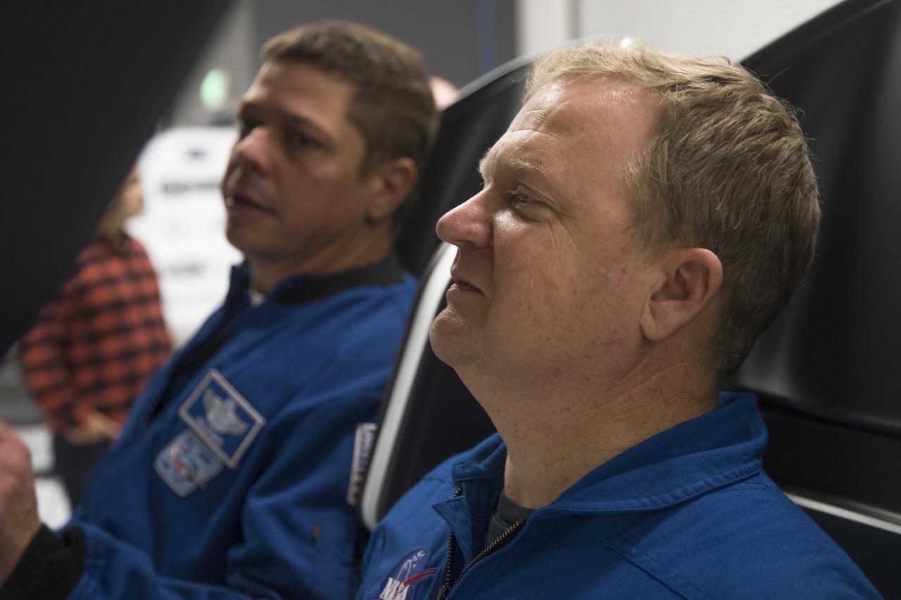 Astronauts Eric Boe, right, and Bob Behnken work in a mock-up of the SpaceX Crew Dragon flight deck at the company's Hawthorne, California, headquarters as development of the crew systems continues for eventual missions to the International Space Station.