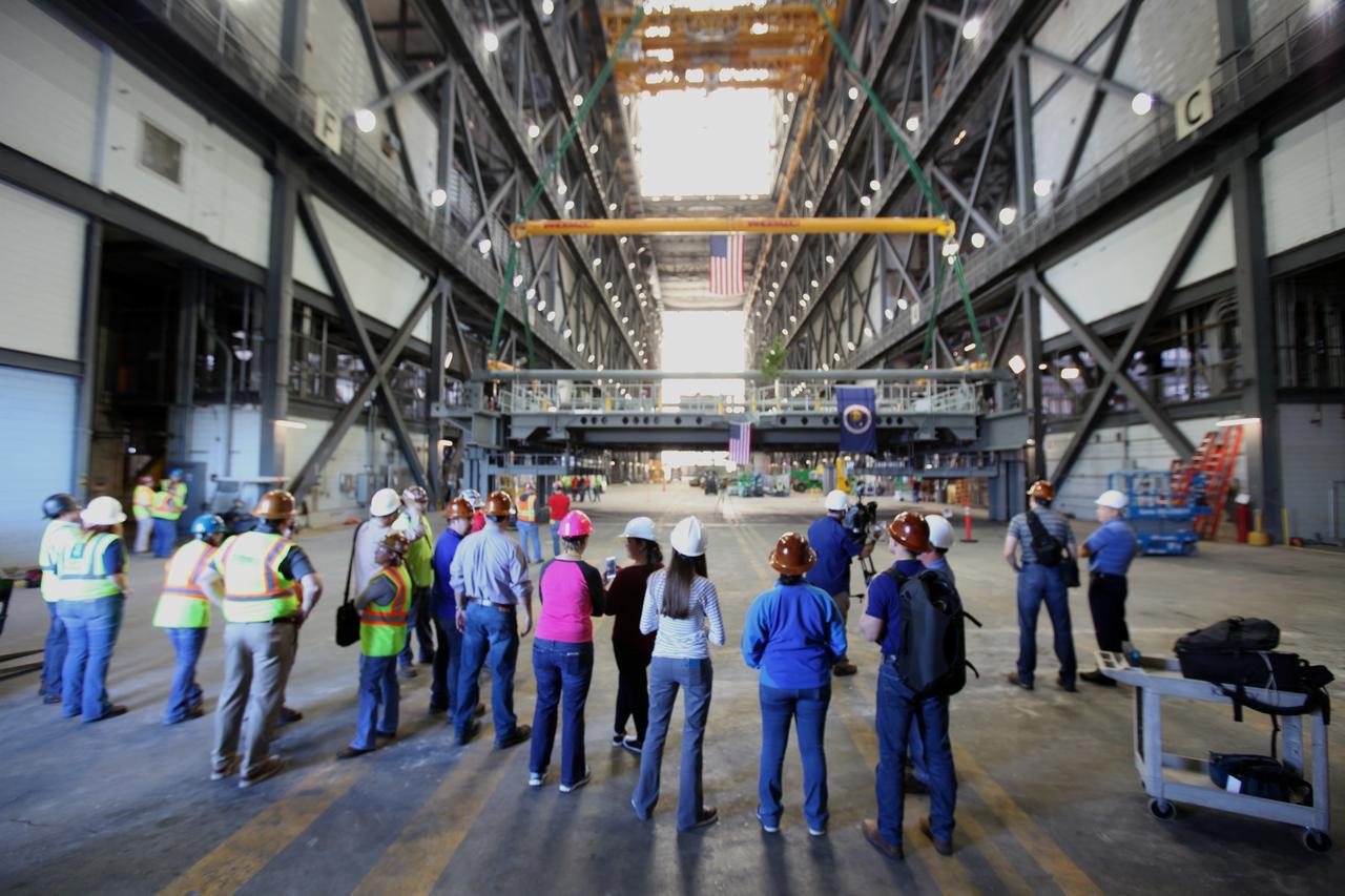 NASA and contractor workers watch as the final work platform, A north, is prepared for lifting in the transfer aisle of the Vehicle Assembly Building (VAB) at NASA's Kennedy Space Center in Florida. The platform will be installed and secured on its rail beam high up on the north wall of High Bay 3. The installation of the final topmost level completes the 10 levels of work platforms, 20 platform halves altogether, that will surround NASA's Space Launch System rocket and the Orion spacecraft and allow access during processing for missions, including the first uncrewed flight test of Orion atop the SLS rocket in 2018. The A-level platforms will provide access to the Orion spacecraft's Launch Abort System for Orion lifting sling removal and installation of the closeout panels. The Ground Systems Development and Operations Program, with support from the center's Engineering Directorate, is overseeing upgrades and modifications to the VAB, including installation of the new work platforms.