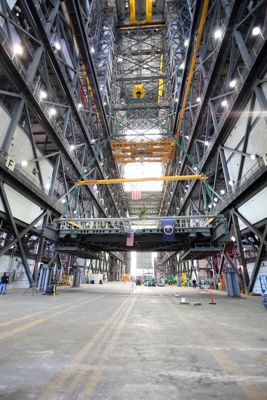 A crane begins to lift the final work platform, A north, in the transfer aisle of the Vehicle Assembly Building (VAB) at NASA's Kennedy Space Center in Florida. The platform will be installed and secured on its rail beam high up on the north wall of High Bay 3. The installation of the final topmost level completes the 10 levels of work platforms, 20 platform halves altogether, that will surround NASA's Space Launch System rocket and the Orion spacecraft and allow access during processing for missions, including the first uncrewed flight test of Orion atop the SLS rocket in 2018. The A-level platforms will provide access to the Orion spacecraft's Launch Abort System for Orion lifting sling removal and installation of the closeout panels. The Ground Systems Development and Operations Program, with support from the center's Engineering Directorate, is overseeing upgrades and modifications to the VAB, including installation of the new work platforms.