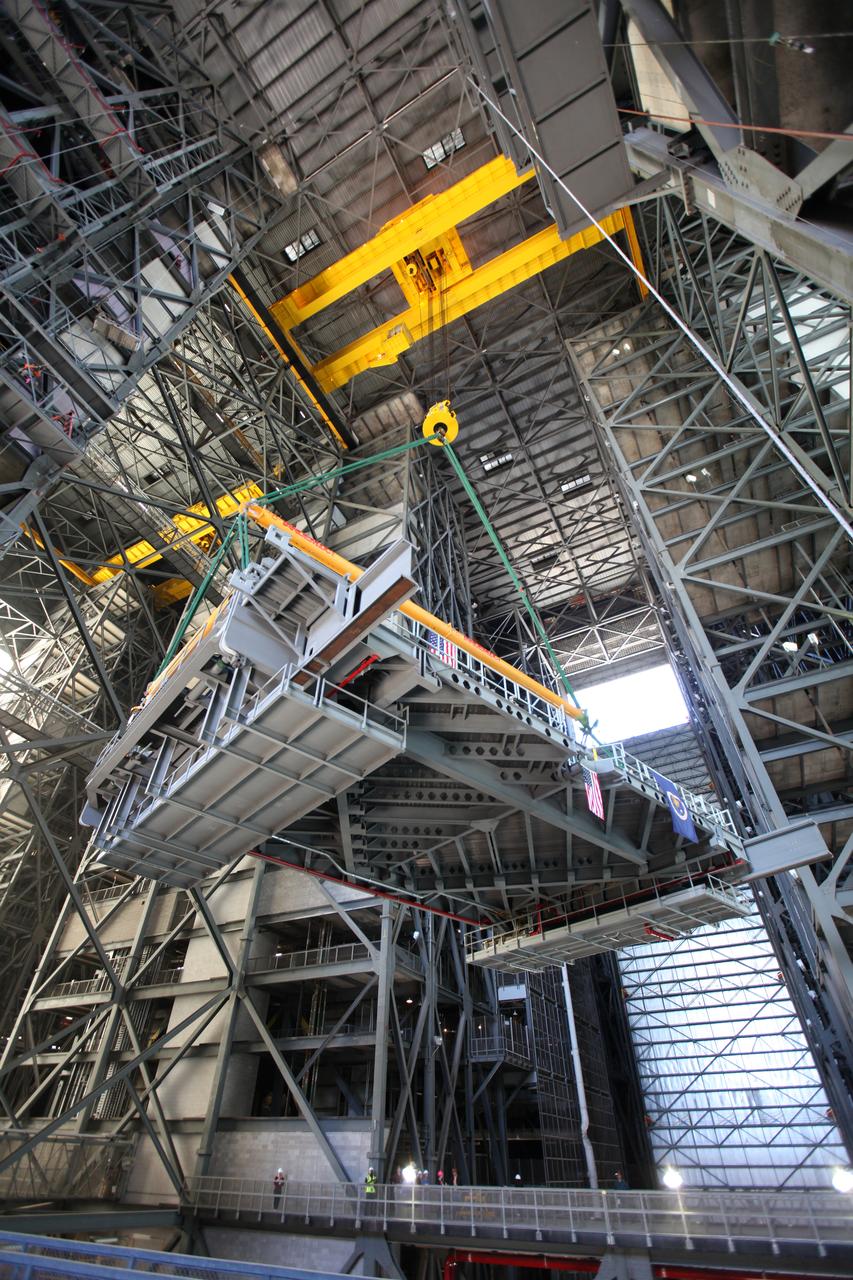 A crane lifts the final work platform, A north, high up in the transfer aisle of the Vehicle Assembly Building (VAB) at NASA's Kennedy Space Center in Florida. The platform will be installed and secured on its rail beam high up on the north wall of High Bay 3. The installation of the final topmost level completes the 10 levels of work platforms, 20 platform halves altogether, that will surround NASA's Space Launch System rocket and the Orion spacecraft and allow access during processing for missions, including the first uncrewed flight test of Orion atop the SLS rocket in 2018. The A-level platforms will provide access to the Orion spacecraft's Launch Abort System for Orion lifting sling removal and installation of the closeout panels. The Ground Systems Development and Operations Program, with support from the center's Engineering Directorate, is overseeing upgrades and modifications to the VAB, including installation of the new work platforms. 
