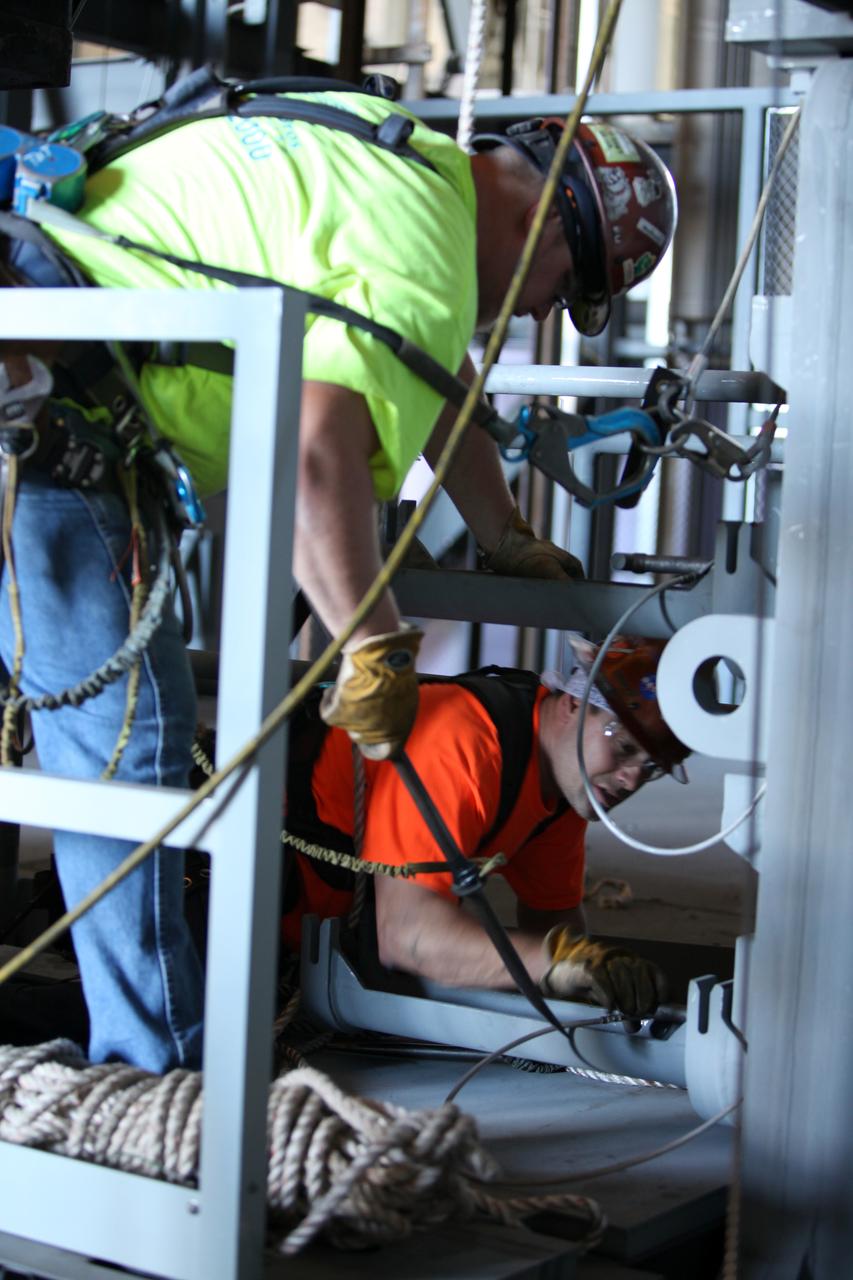 High up in the Vehicle Assembly Building (VAB) at NASA's Kennedy Space Center in Florida, construction workers assist with the installation of the final work platform, A north, in High Bay 3, as a crane lowers the platform into place. The platform will be installed and secured on its rail beam high up on the north wall of the high bay. The installation of the final topmost level completes the 10 levels of work platforms, 20 platform halves altogether, that will surround NASA's Space Launch System rocket and the Orion spacecraft and allow access during processing for missions, including the first uncrewed flight test of Orion atop the SLS rocket in 2018. The A-level platforms will provide access to the Orion spacecraft's Launch Abort System for Orion lifting sling removal and installation of the closeout panels. The Ground Systems Development and Operations Program, with support from the center's Engineering Directorate, is overseeing upgrades and modifications to the VAB, including installation of the new work platforms. 