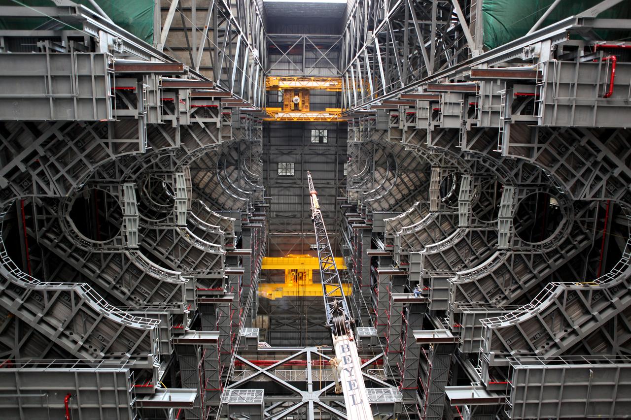 High up in the Vehicle Assembly Building (VAB) at NASA's Kennedy Space Center in Florida, an overhead crane has lowered the final work platform, A north, into place for installation in High Bay 3. The platform is being installed and secured on its rail beam high up on the north wall of the high bay. In view below the A platforms are the nine previously installed platform levels. The installation of the final topmost level completes the 10 levels of work platforms, 20 platform halves altogether, that will surround NASA's Space Launch System rocket and the Orion spacecraft and allow access during processing for missions, including the first uncrewed flight test of Orion atop the SLS rocket in 2018. The A-level platforms will provide access to the Orion spacecraft's Launch Abort System for Orion lifting sling removal and installation of the closeout panels. The Ground Systems Development and Operations Program, with support from the center's Engineering Directorate, is overseeing upgrades and modifications to the VAB, including installation of the new work platforms.