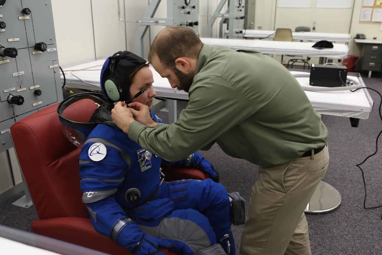 A suit technician prepares for a pressure test of Boeing's new spacesuit designed to be worn by astronauts flying on the CST-100 Starliner. Seen here being worn in the same manner as it will on launch day inside Crew Quarters at NASA's Kennedy Space Center in Florida, the suit is lighter and more flexible than previous spacesuits but retains the ability to pressurize in an emergency. Astronauts will wear the suit throughout the launch and ascent into orbit as well as on the way back to Earth. Starliners will launch atop Atlas V rockets from United Launch Alliance on missions including flights to the International Space Station for NASA's Commercial Crew Program. Photo credit: NASA/Cory Huston