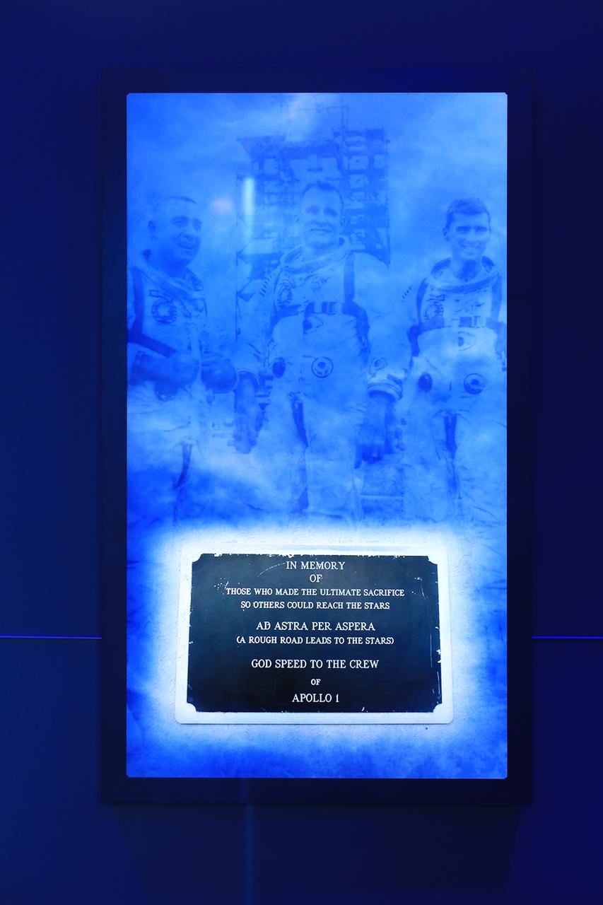 A display screen showing the memorial plaque that is in place at Launch Complex 34 is shown inside the new tribute to the crew of Apollo 1 who perished in a fire at the launch pad on Jan. 27, 1967, during training for the mission. Astronauts Gus Grissom, Ed White II and Roger Chaffee were lost during the fire. The tribute at the Apollo/Saturn V Center at NASA's Kennedy Space Center opened Jan. 27, 2017, 50 years after the crew of three was lost. It features numerous items recalling the lives of the three astronauts. It also includes the three-part hatch to the spacecraft itself, the first time any part of the Apollo 1 spacecraft has been displayed publicly. A version of the hatch after it was redesigned is also showcased as an example of improvements NASA made throughout the agency and to the Apollo spacecraft that would later carry astronauts to the moon.