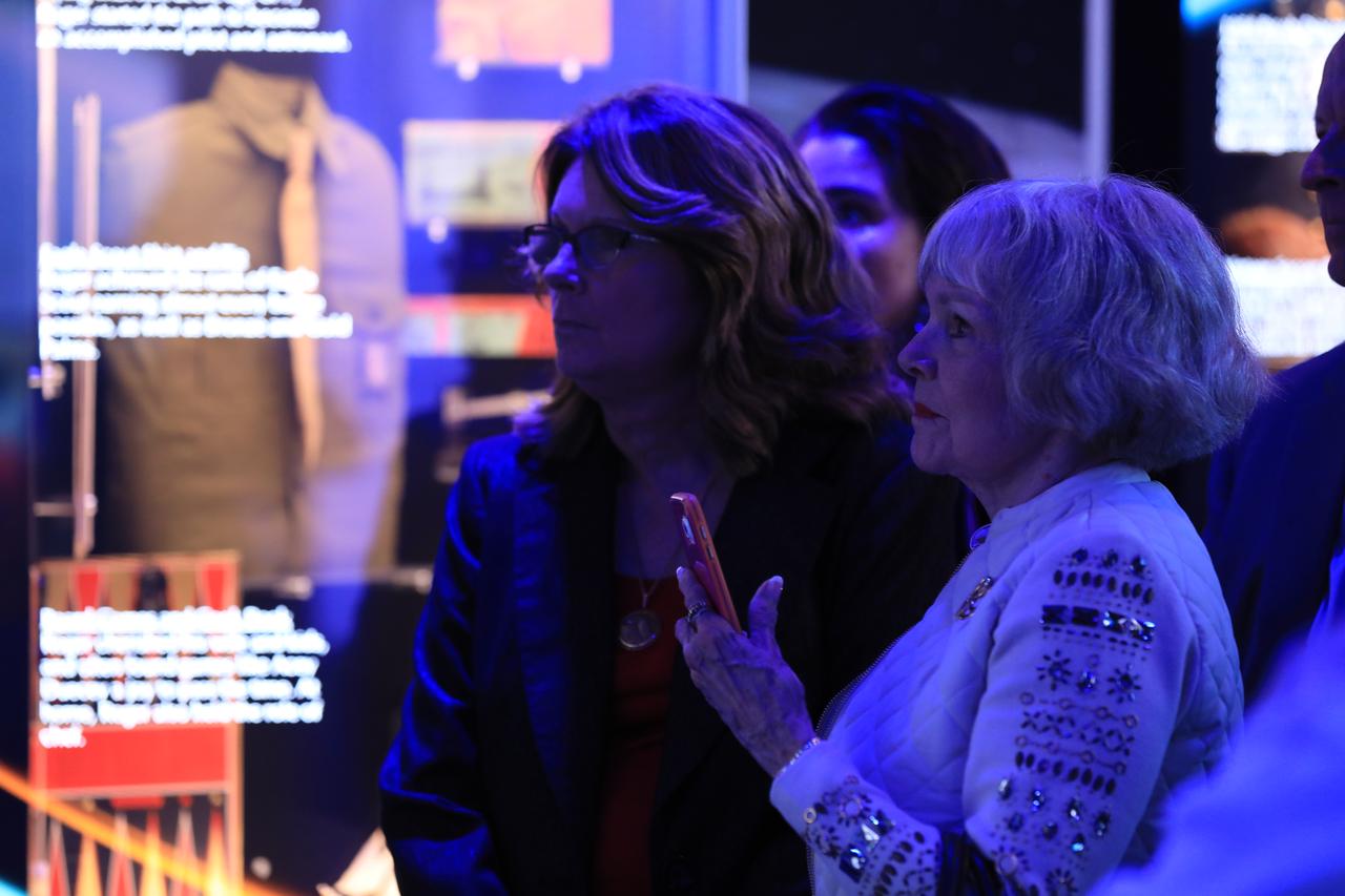 Martha Chaffee and Sheryl Chaffee, widow and daughter of astronaut Roger Chaffee, respectively, look at areas of the newly opened Apollo 1 tribute at the Apollo/Saturn V Center at NASA's Kennedy Space Center opened Jan. 27, 2017. Astronauts Gus Grissom, Ed White II and Chaffee perished in a fire at the launch pad on Jan. 27, 1967, during training for the mission. The tribute highlights the lives and careers of the astronauts. The tribute features numerous items recalling the lives of the three astronauts. The tribute also includes the three-part hatch to the spacecraft itself, the first time any part of the Apollo 1 spacecraft has been displayed publicly. A version of the hatch after it was redesigned is also showcased as an example of improvements NASA made throughout the agency and to the Apollo spacecraft that would later carry astronauts to the moon.