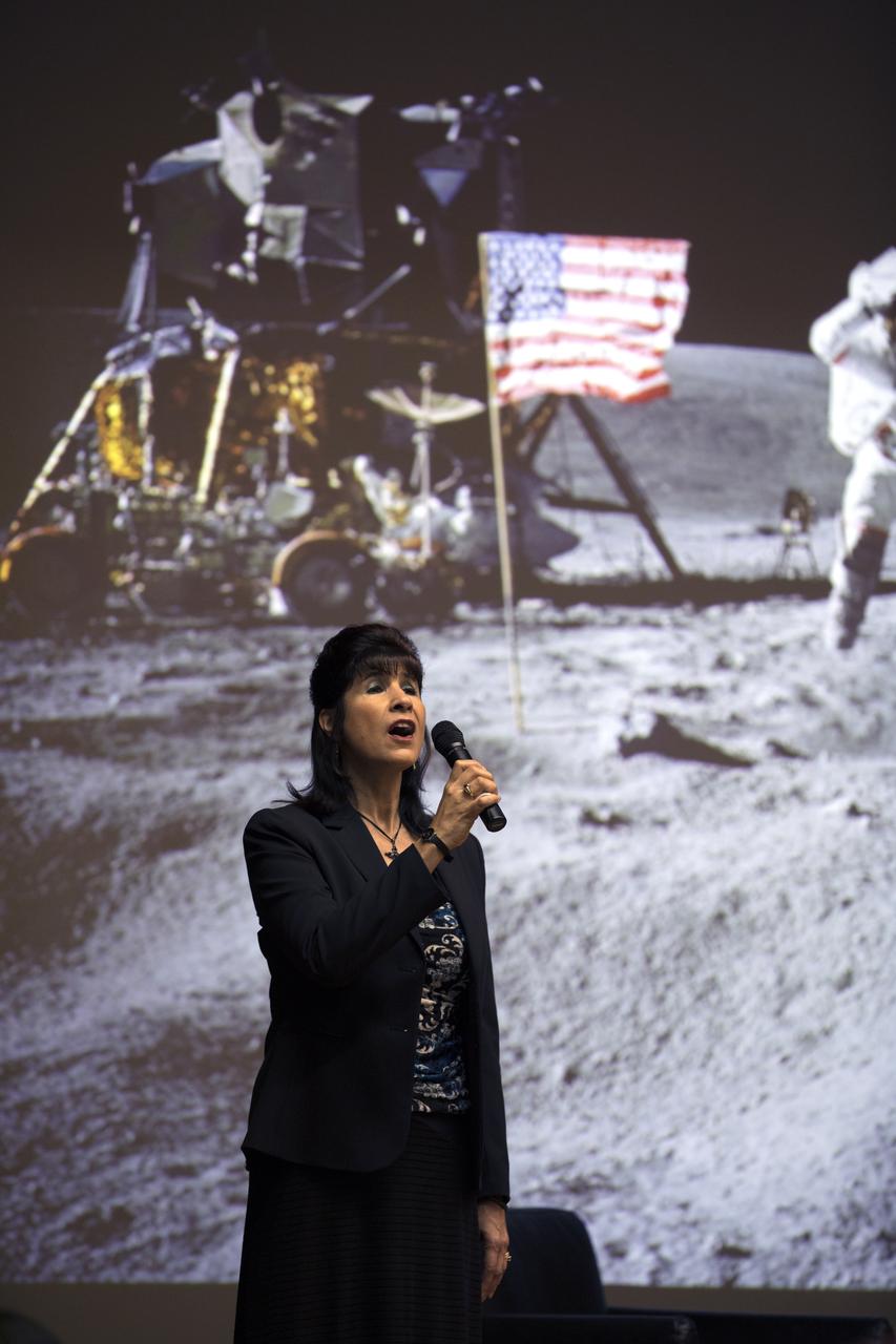 Suzy Cunningham, with the Communication and Public Engagement Directorate, sings the National Anthem before the start of the Apollo 1 Lessons Learned presentation in the Training Auditorium at NASA’s Kennedy Space Center in Florida. The program's theme was "To There and Back Again." Guest panelists included Charlie Duke, former Apollo 16 astronaut and member of the Apollo 1 Emergency Egress Investigation Team; Ernie Reyes, retired, Apollo 1 senior operations engineer; and John Tribe, retired, Apollo 1 Reaction and Control System lead engineer. The event helped pay tribute to the Apollo 1 crew, Gus Grissom, Ed White II, and Roger Chaffee.