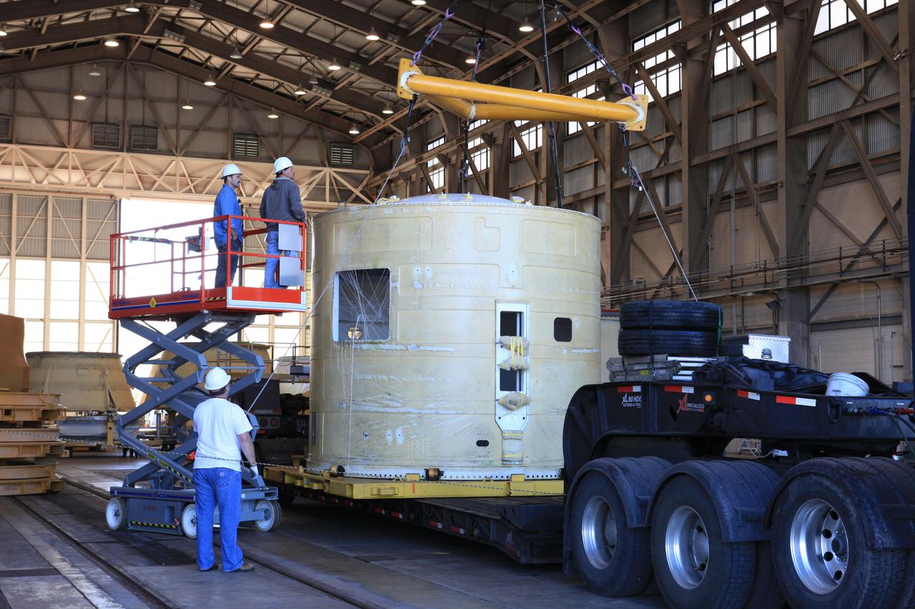 Inside the Hangar AF facility at Cape Canaveral Air Force Station in Florida, technicians with Orbital ATK monitor the progress as a crane is attached to the left-hand forward skirt for NASA's Space Launch System (SLS) solid rocket boosters. The forward skirt was transported from booster prime contractor Orbital ATK in Promontory, Utah. The forward skirt will be staged in Hangar AF where refurbishment will continue. It will be inspected and prepared for use on the left-hand solid rocket booster for Exploration Mission 1. NASA's Orion spacecraft will fly atop the SLS rocket on its first uncrewed flight test. 