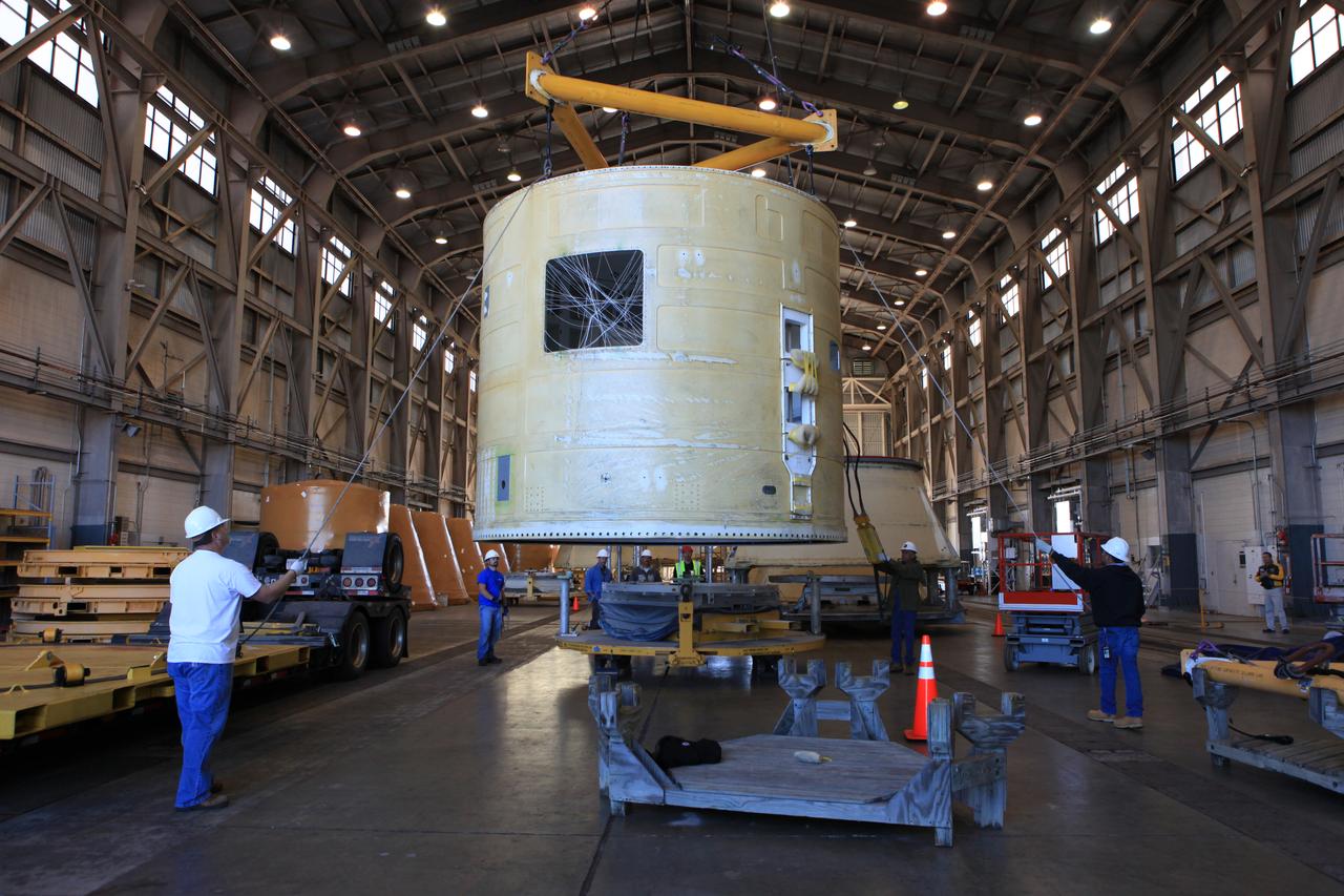 Technicians with Orbital ATK assist as a crane moves the left-hand forward skirt for NASA's Space Launch System (SLS) solid rocket boosters to a stand inside the Hangar AF facility at Cape Canaveral Air Force Station in Florida. The forward skirt was transported from booster prime contractor Orbital ATK in Promontory, Utah. The forward skirt will be staged in Hangar AF where refurbishment will continue. It will be inspected and prepared for use on the left-hand solid rocket booster for Exploration Mission 1. NASA's Orion spacecraft will fly atop the SLS rocket on its first uncrewed flight test.