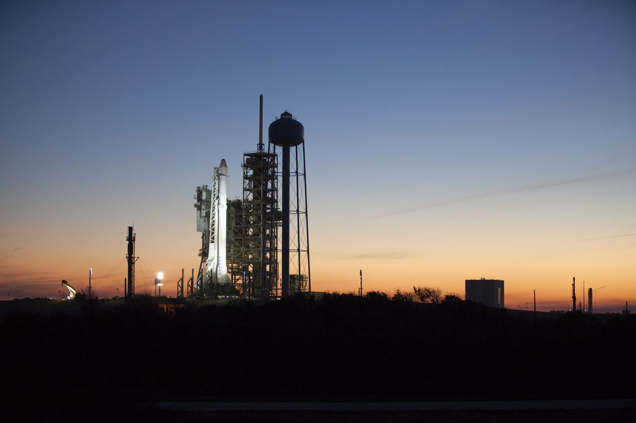 As sun sets, a Falcon 9 rocket stands ready for liftoff at the Kennedy Space Center's Launch Complex 39A. The historic launch site now is operated by SpaceX under a property agreement signed with NASA. In the background is the Vehicle Assembly Building. The rocket will boost a Dragon resupply spacecraft to the International Space Station. Liftoff is scheduled for 10:01 a.m. EST on Feb. 18. On its 10th commercial resupply services mission to the space station, Dragon will bring up 5,000 pounds of supplies, such as the Stratospheric Aerosol and Gas Experiment (SAGE) III instrument to further study ozone in the atmosphere. Once mounted on the space station, SAGE III will measure the Earth’s sunscreen, or ozone, along with other gases and aerosols, or tiny particles in the atmosphere.