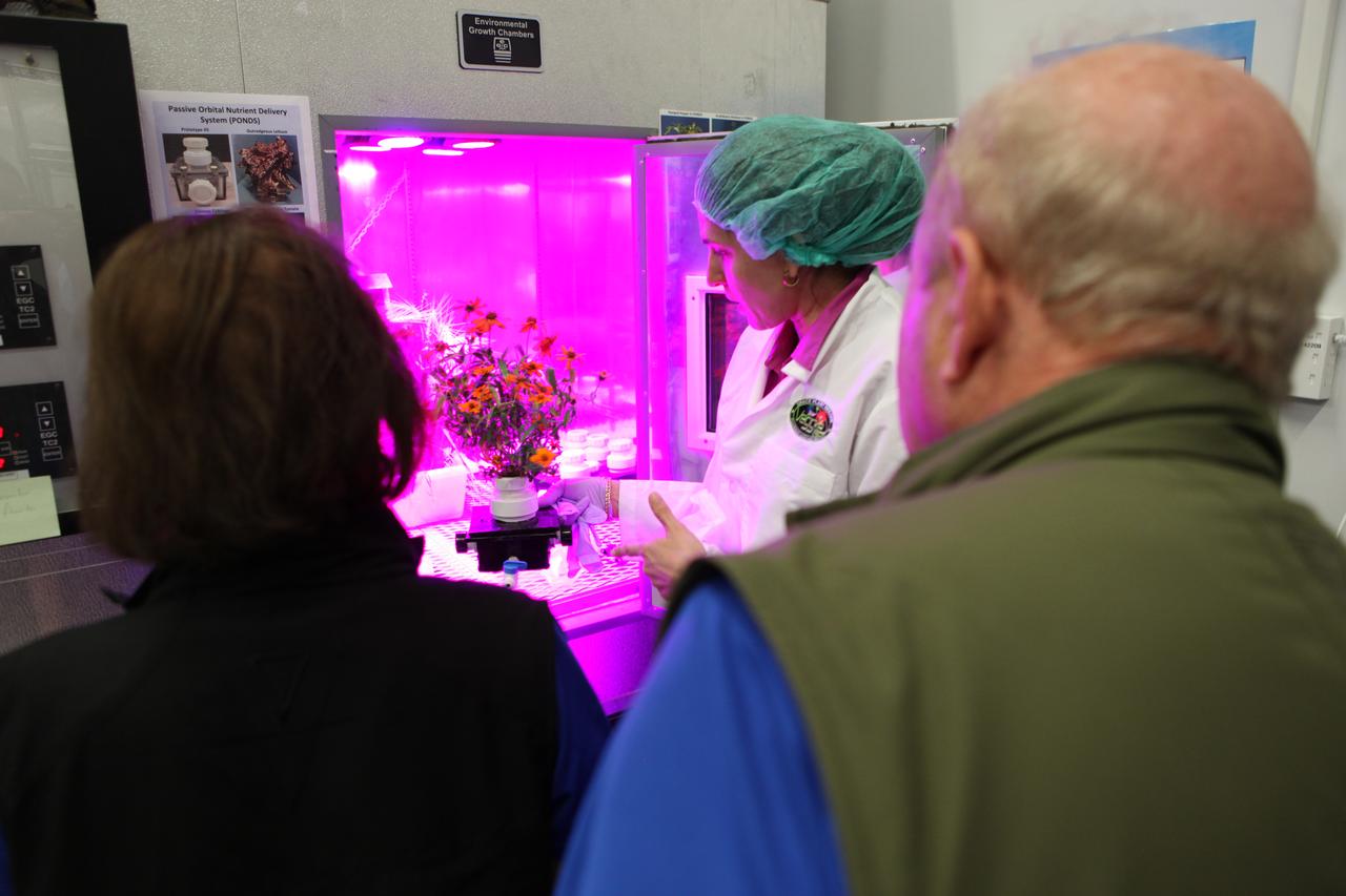 Gioia Massa, NASA payload scientist for Veggie, center, shows Ed and Betty Rosenthal, founders of Florikan Fertilizer Corp., the ground control experiments in the Veggie Lab at NASA's Kennedy Space Center on Feb. 16. 