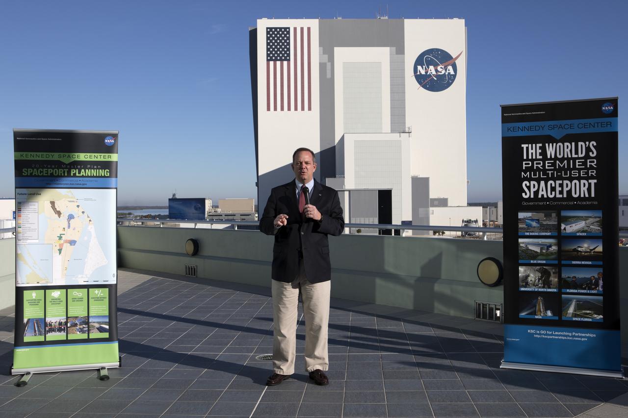 Tom Engler, director of Center Planning and Development at NASA's Kennedy Space Center, speaks to members of the news media on the balcony of Operations Support Building II describing the site's transition from a primarily government-only facility to a premier, multi-user spaceport. In the background is the Vehicle Assembly Building (VAB). Modifications were recently completed in the VAB where new work platforms were installed to support processing of NASA's Space Launch System rocket designed to send the Orion spacecraft on missions beyond low-Earth orbit.