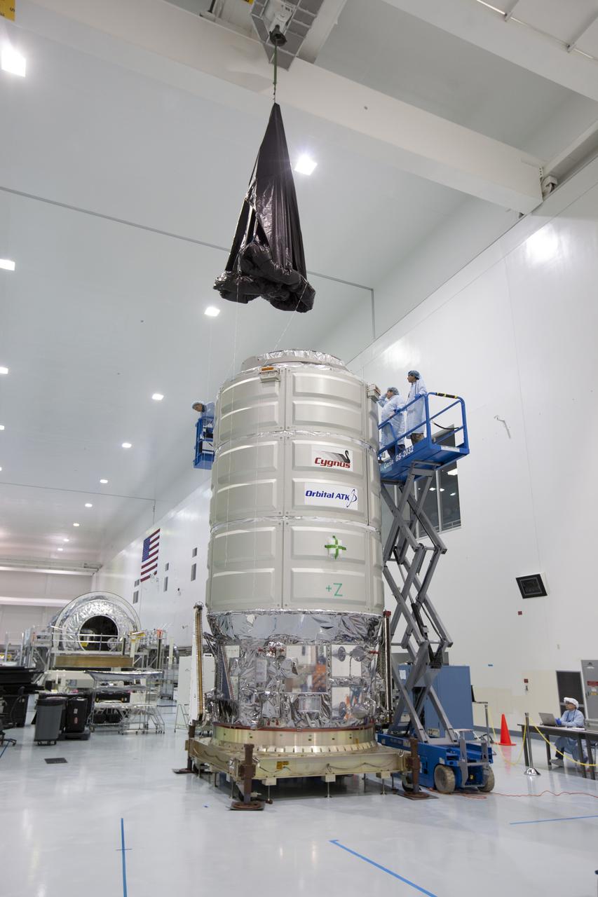 In the Space Station Processing Facility high bay at NASA's Kennedy Space Center in Florida, technicians are preparing to assist as a crane is used to lower a protective covering around Orbital ATK's CYGNUS pressurized cargo module. The Orbital ATK CRS-7 commercial resupply services mission to the International Space Station is scheduled to launch atop a United Launch Alliance Atlas V rocket from Space Launch Complex 41 at Cape Canaveral Air Force Station on March 19, 2017. CYGNUS will deliver thousands of pounds of supplies, equipment and scientific research materials to the space station.
