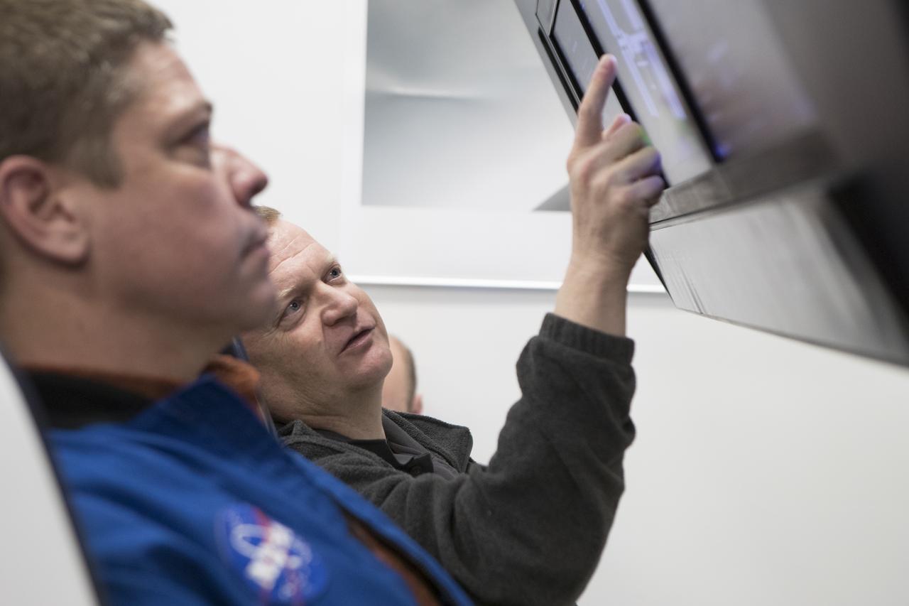 During a tour of SpaceX headquarters in Hawthorne, California, commercial crew astronauts Bob Behnken, left, and Eric Boe participate in joint test team training using mockup components of the Crew Dragon on Feb. 23, 2017. Crew Dragon is being developed and manufactured in partnership with NASA's Commercial Crew Program to return human spaceflight capabilities to the U.S.