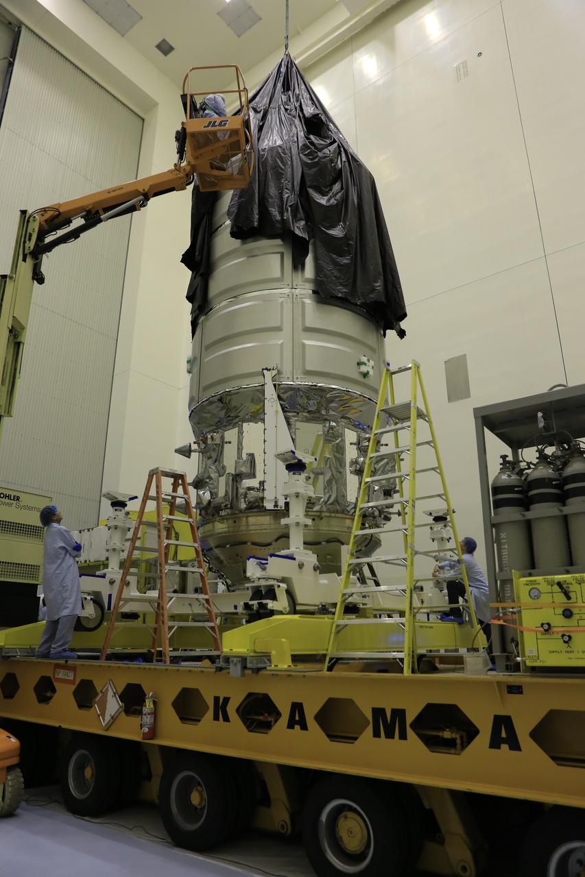 Inside the Payload Hazardous Servicing Facility at NASA's Kennedy Space Center in Florida, technicians assist as a crane is used to remove the protective covering from Orbital ATK's CYGNUS pressurized cargo module on a KAMAG transporter. In the PHSF, Cygnus will be moved to a work stand for final propellant loading and late cargo stowage. The Orbital ATK CRS-7 commercial resupply services mission to the International Space Station is scheduled to launch atop a United Launch Alliance Atlas V rocket from Space Launch Complex 41 at Cape Canaveral Air Force Station on March 19, 2017. CYGNUS will deliver thousands of pounds of supplies, equipment and scientific research materials to the space station. 