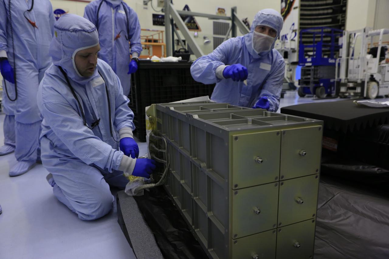 Inside the Payload Hazardous Servicing Facility at NASA's Kennedy Space Center in Florida, technicians prepare several Nanoracks for installation on the exterior of the Orbital ATK Cygnus pressurized cargo module. The Orbital ATK CRS-7 commercial resupply services mission to the International Space Station is scheduled to launch atop a United Launch Alliance Atlas V rocket from Space Launch Complex 41 at Cape Canaveral Air Force Station no earlier than March 21, 2017. Cygnus will deliver 7,600 pounds of supplies, equipment and scientific research materials to the space station. 