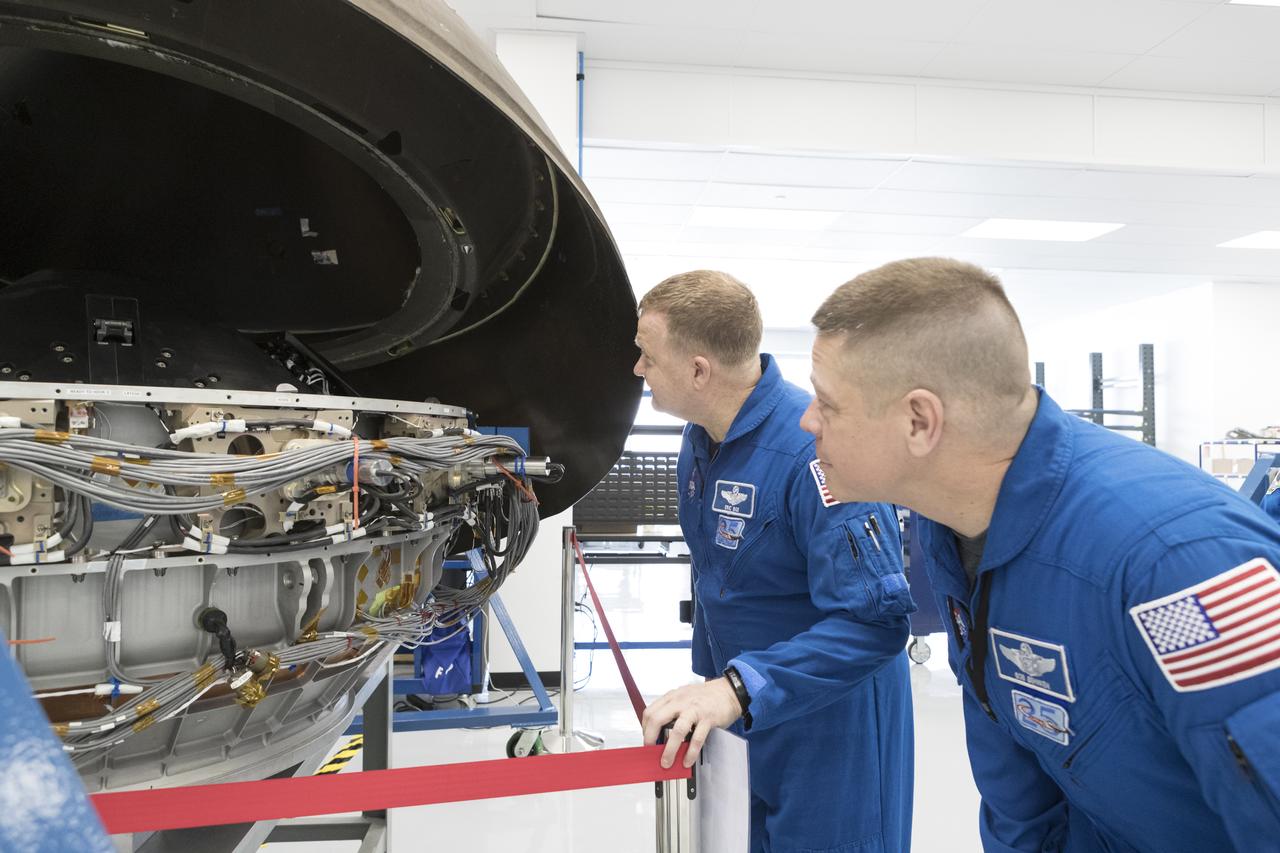 During a tour of SpaceX headquarters in Hawthorne, California, commercial crew astronauts Eric Boe, left, and Bob Behnken view the Crew Dragon on March 8, 2017. Crew Dragon is being developed and manufactured in partnership with NASA's Commercial Crew Program to return human spaceflight capabilities to the U.S.