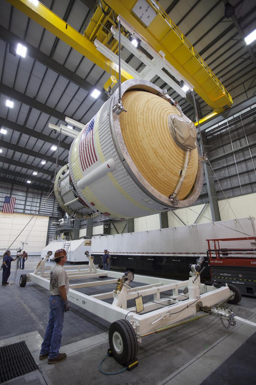 Inside the United Launch Alliance (ULA) Horizontal Integration Facility at Cape Canaveral Air Force Station in Florida, technicians monitor the progress as a crane lowers the Interim Cryogenic Propulsion Stage (ICPS) for NASA's Space Launch System rocket to a movable transport stand. The ICPS is the first integrated piece of flight hardware to arrive for the SLS. The ICPS arrived from the ULA facility in Decatur, Alabama. The ICPS is the in-space stage that is located toward the top of the rocket, between the Launch Vehicle Stage Adapter and the Orion Spacecraft Adapter. It will provide some of the in-space propulsion during Orion's first flight test atop the SLS on Exploration Mission 1. 