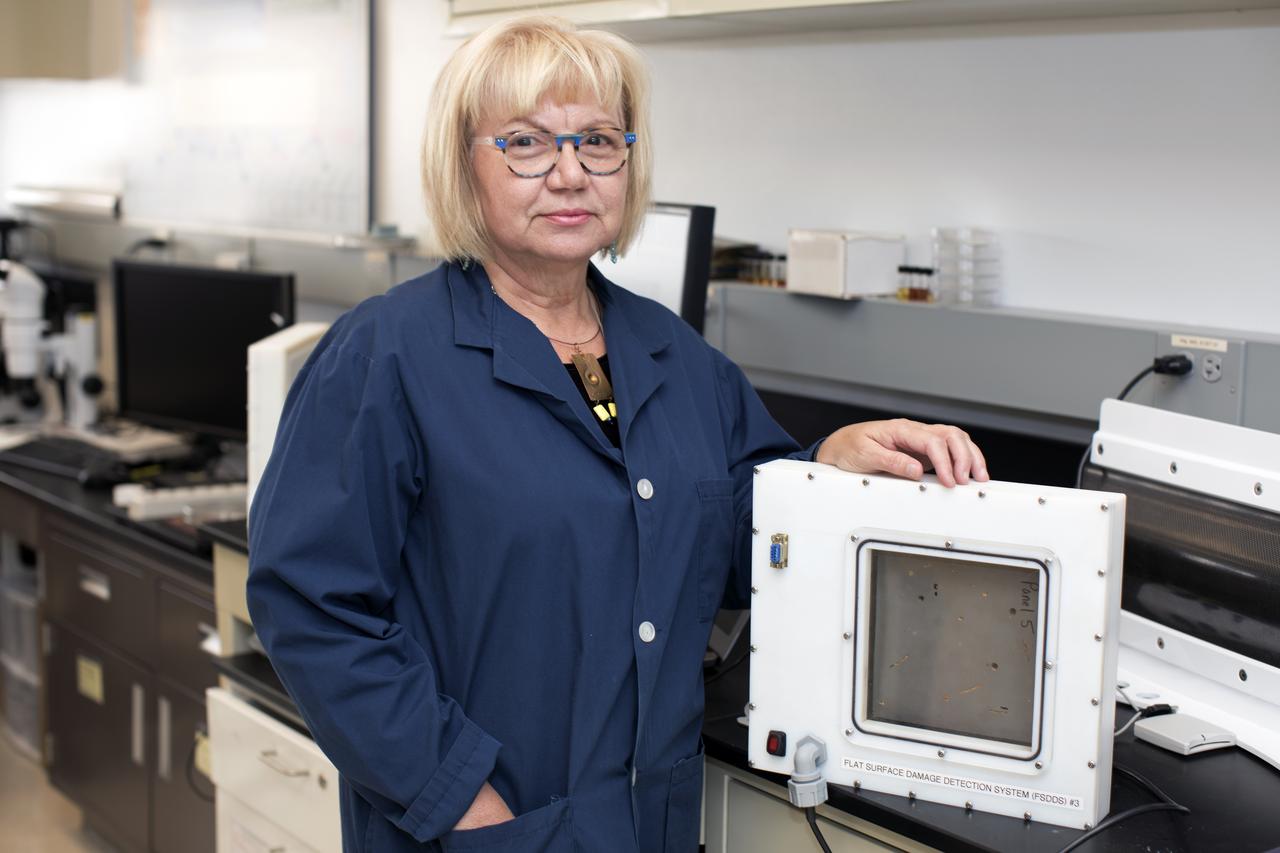 Martha Williams, who leads the team inventing the Flexible Damage Detection System, stands in a laboratory with a prototype at NASA's Kennedy Space Center in Florida. The system uses circuits printed on thin thermal film and specialized software. The system is designed to show where damage to a surface occurs and how severe it may be. It could offer astronauts a real-time update on their spacecraft's condition during a mission without requiring a spacewalk. 