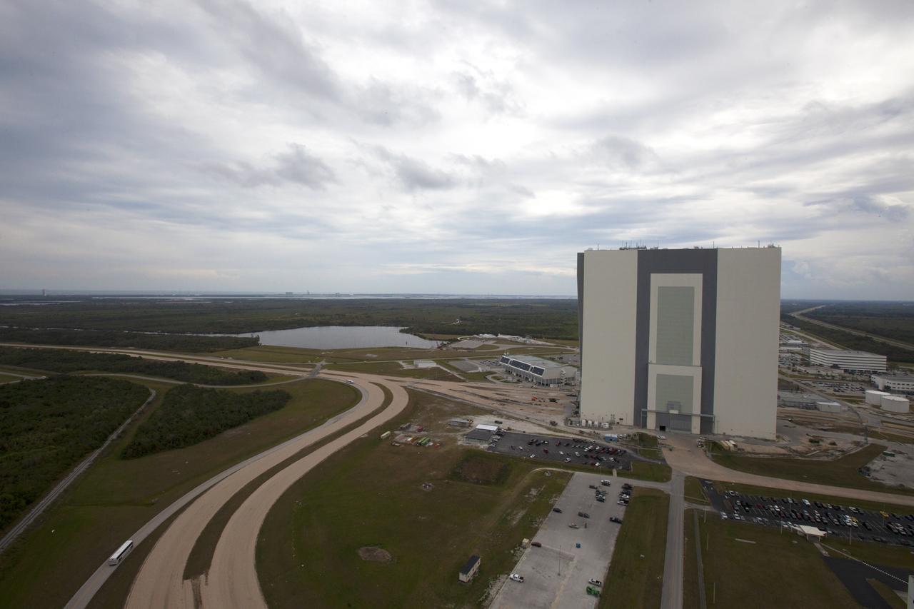 A view of the north side of the Vehicle Assembly Building (VAB) from the top of the mobile launcher tower at NASA's Kennedy Space Center in Florida. Inside the VAB, 10 levels of platforms, 20 platform halves altogether, have been installed in High Bay 3. The platforms will surround NASA's Space Launch System (SLS) rocket and the Orion spacecraft and allow access during processing for missions, including the first uncrewed flight test of Orion atop the SLS rocket in 2018. Crawler-transporter 2 will carry the rocket and spacecraft atop the mobile launcher to Launch Pad 39B for Exploration Mission 1. The Ground Systems Development and Operations Program, with support from the center's Engineering Directorate, is overseeing upgrades and modifications to the VAB and the mobile launcher. 